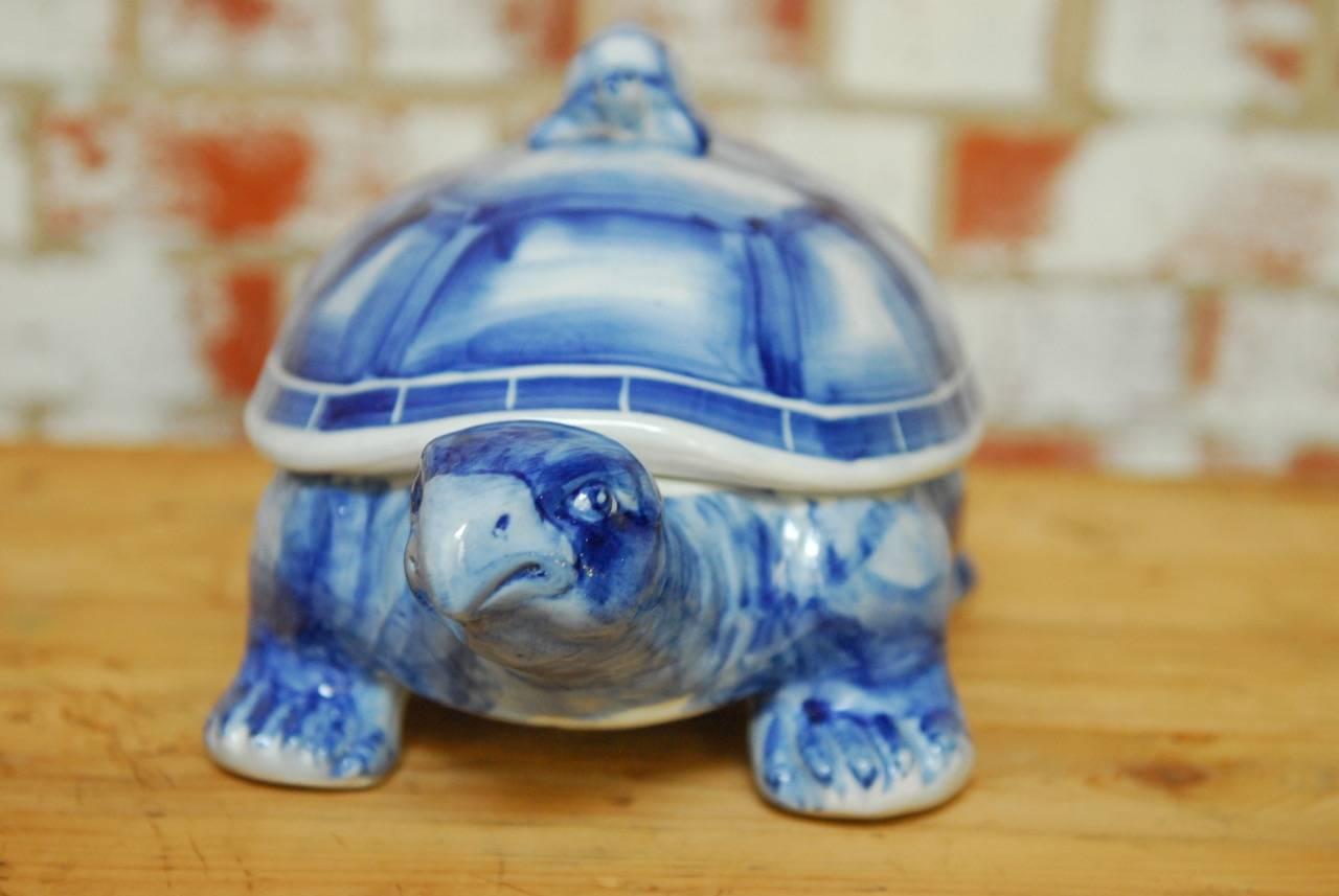 Charming blue and white porcelain turtle trinket box. Features a removable top shell with a baby turtle handle. Hand-painted smooth glazed finish.