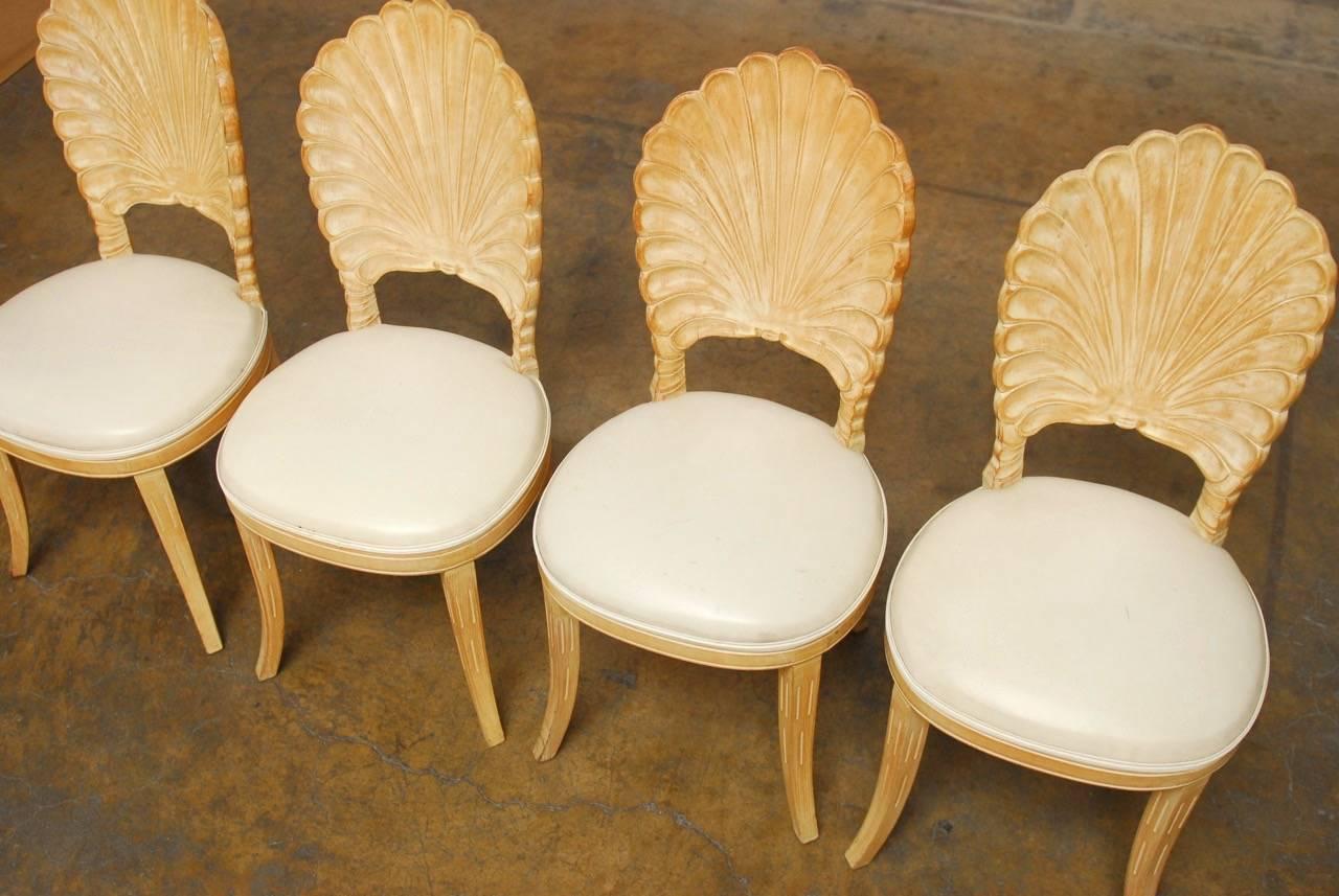 Elegant set of four Venetian Grotto style shell back dining chairs produced in Italy in the Hollywood Regency taste. Features a hand-carved fruitwood framed with a scalloped shell motif back. Beautiful light blonde wood with the original finish and