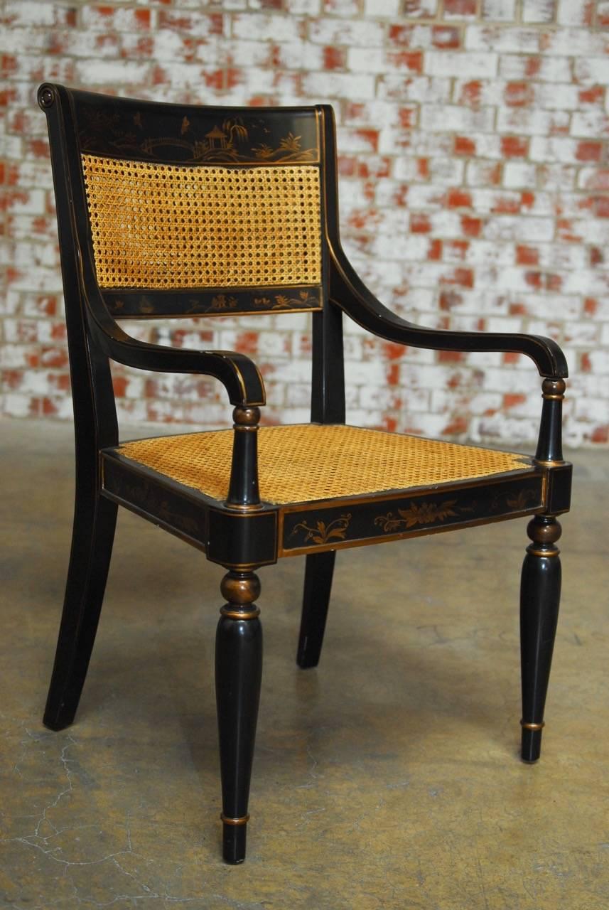 Parcel-gilt Regency style caned armchair or library chair by Bernhardt featuring a chinoiserie decorated frame. The ebonized lacquer frame has scenic reserves in the Asian taste of pagodas and foliate. The armchair has a cane seat and a double caned