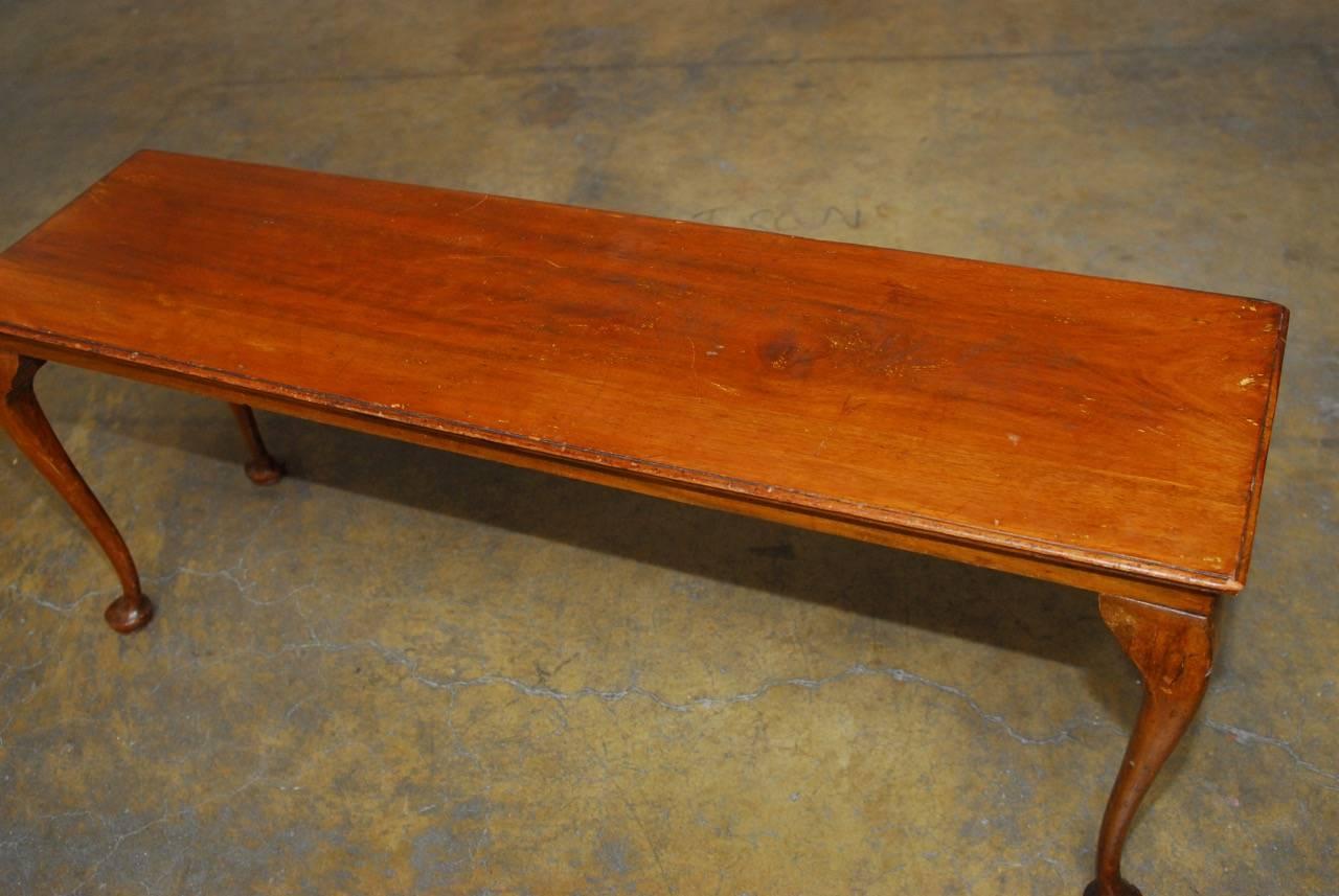 Elegant 19th century carved walnut bench or console table made in the Queen Anne revival taste of the late 1800s. Rectangular top panel with a decorative ogee edge and supported by delicate cabriole legs ending with pad feet. Handsome age