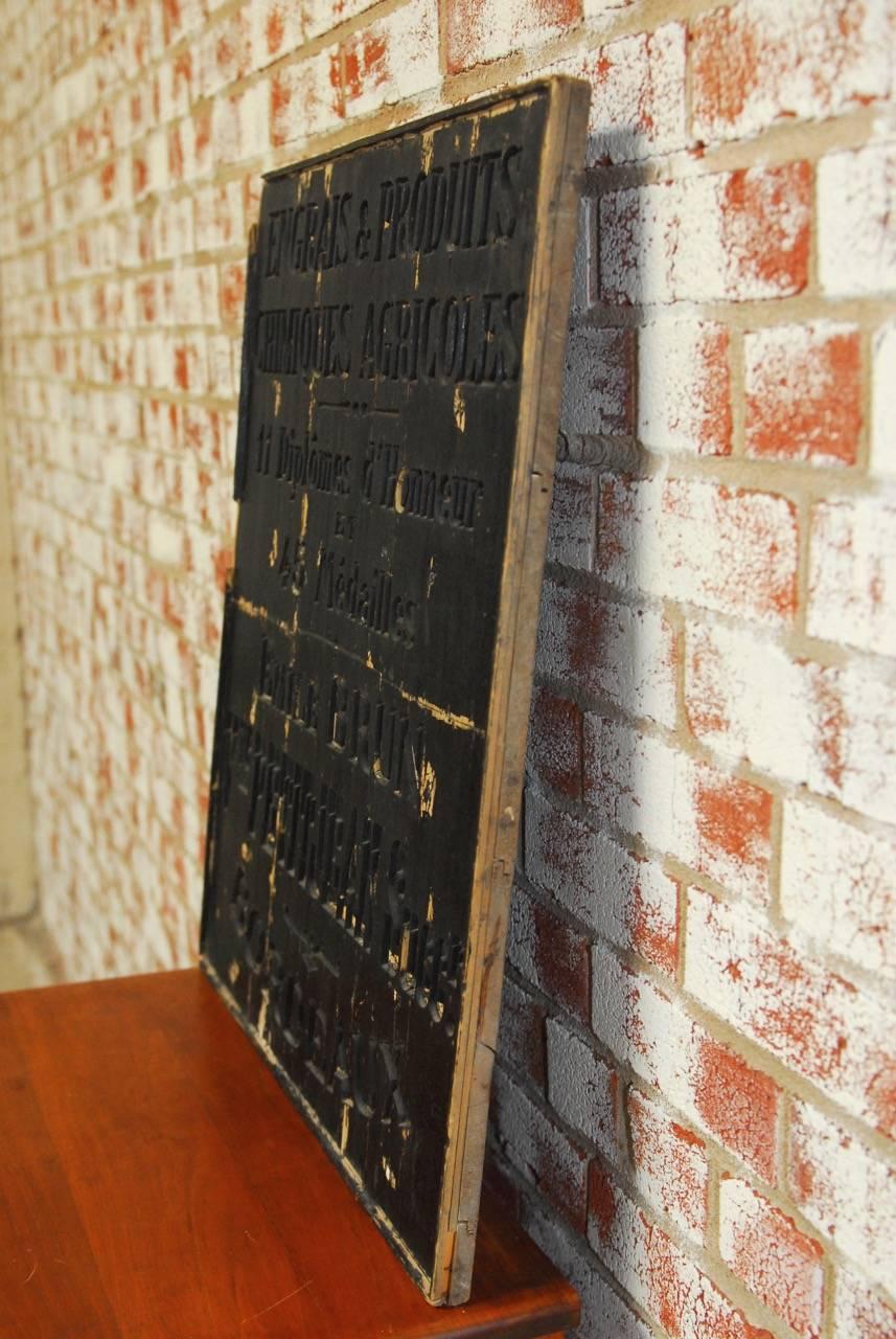 Interesting black lacquered French shop trade sign from the Bordeaux wine region featuring the name and address of a fertilizer company. Engraved ebonized wood and mounted on a plaque with a rich, vintage patina.