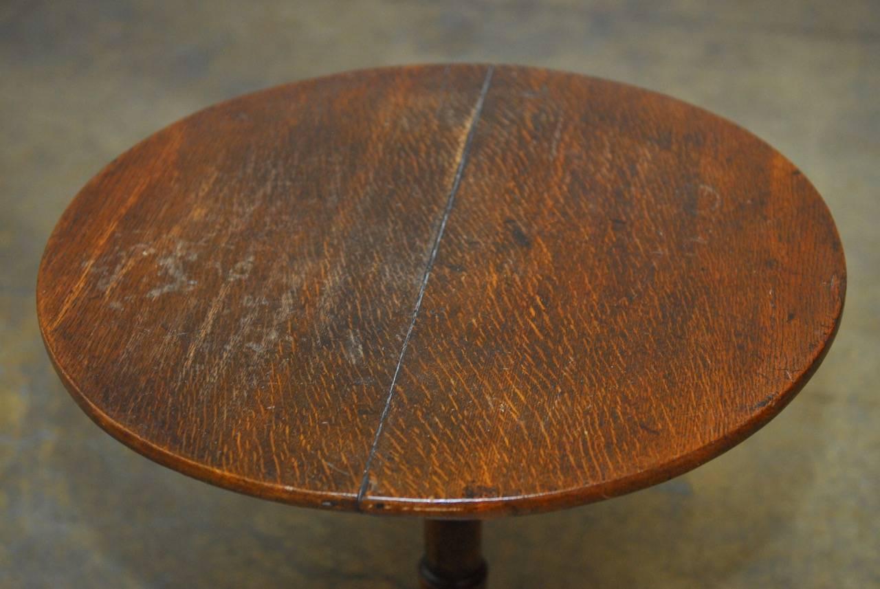 Rustic 19th century tilt-top mahogany tea table or dessert table constructed from mahogany. Features a round top supported by a turned column with tripod legs. Deep, rich finish and vintage patina give this little table a lot of character. 