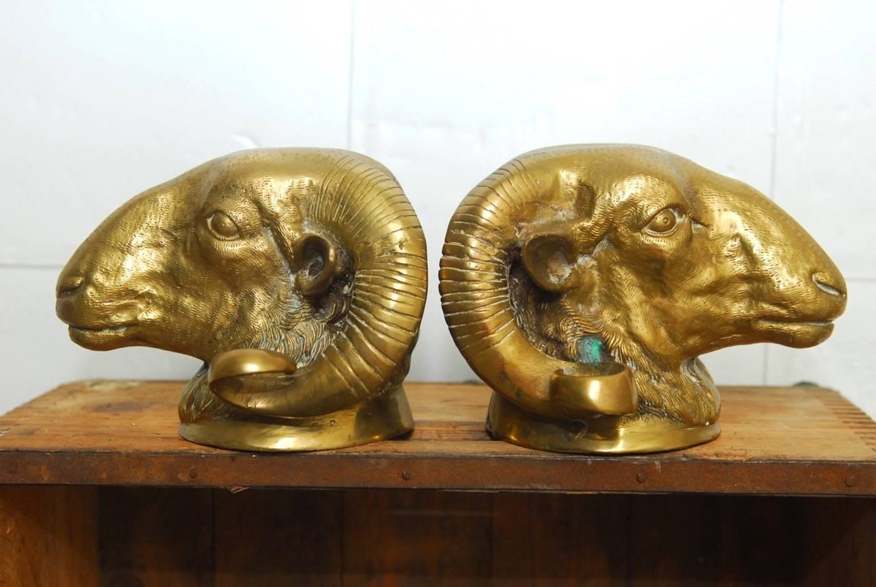 Impressive pair of patinated brass ram's head sculptures featuring long curled horns. Made in Italy with intricate detailed heads. Heavy enough for use as bookends.