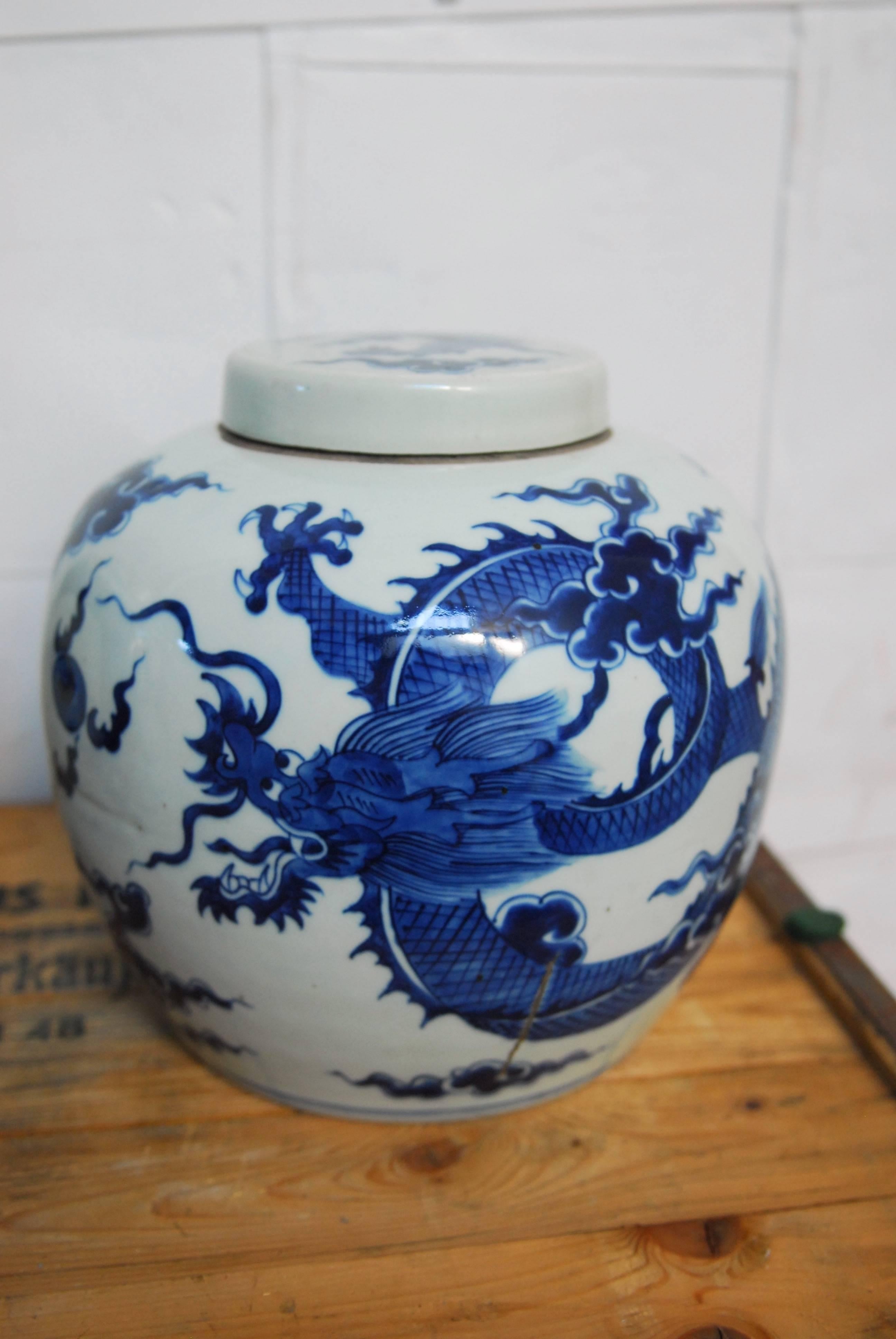 Dramatic pair of Chinese blue and white glazed porcelain ginger jars featuring a dragon motif. Beautifully decorated with matching lids and stamped with a Kangxi double blue circle stamp.