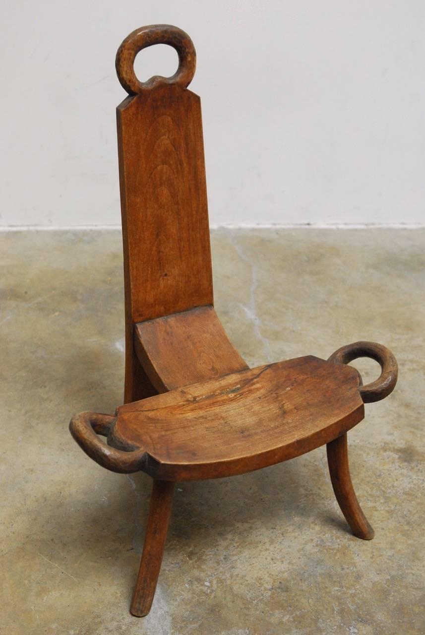19th century English carved birthing chair. Features large handles on each side and top and a shaped saddle seat. Supported by three splayed legs and constructed with mortise and Tenon joinery. Carved from 1