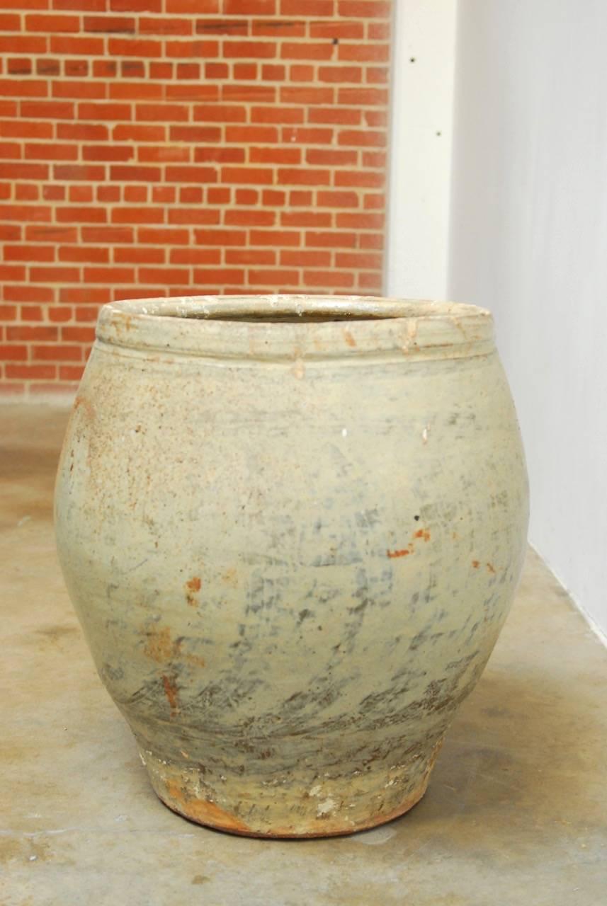 Large glazed terracotta storage jar or planter with a beautiful distressed finish. Subtle lid on top with an illegible stamp on upper side. 