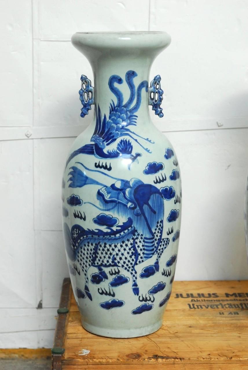 Interesting pair of Chinese blue and white ceramic vases featuring hand-painted scenes of dragons and phoenixes amid Ruyi clouds. Beautifully shaped vessels with a rounded top lid and applied handles on each side. Deep and vibrant indigo blue glazed