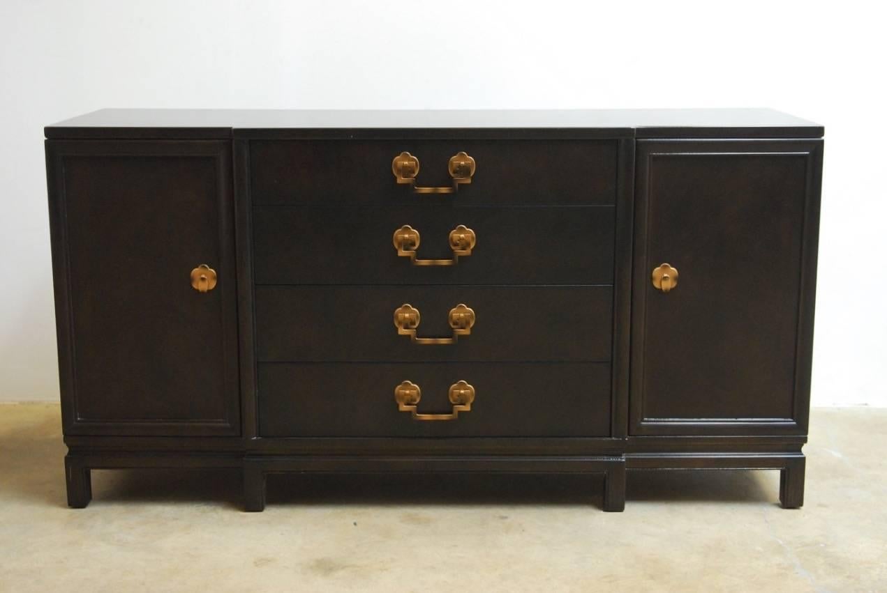 Fabulous Mid-Century Modern mahogany four-drawer dresser, credenza, or sideboard by Landstrom. Featuring an Asian inspired case attached to a six-leg stand. Elegant copper toned hardware with Greek key handles and quatrefoil design door pulls. Each