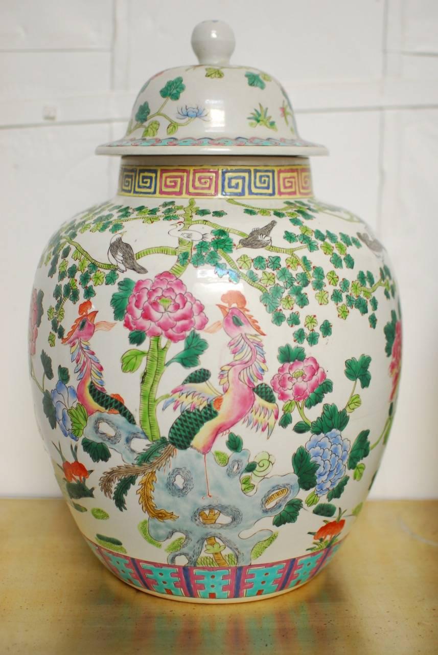 Large pair of Chinese porcelain ginger jars featuring flowers and exotic birds decorated in the "famille rose" palette of soft opaque colors. Classic example of "Fencai" or powder colors introduced during the Kanxi period. The