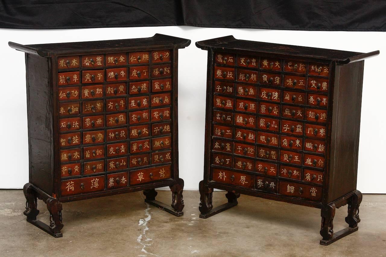 Rare pair of 19th Century Chinese Qing Dynasty apothecary cabinets or herbal medicine chests. Each matching chest has 43 drawers and features an altar style scroll top case. The cabinets are supported by curved legs with decorative faux bamboo motif