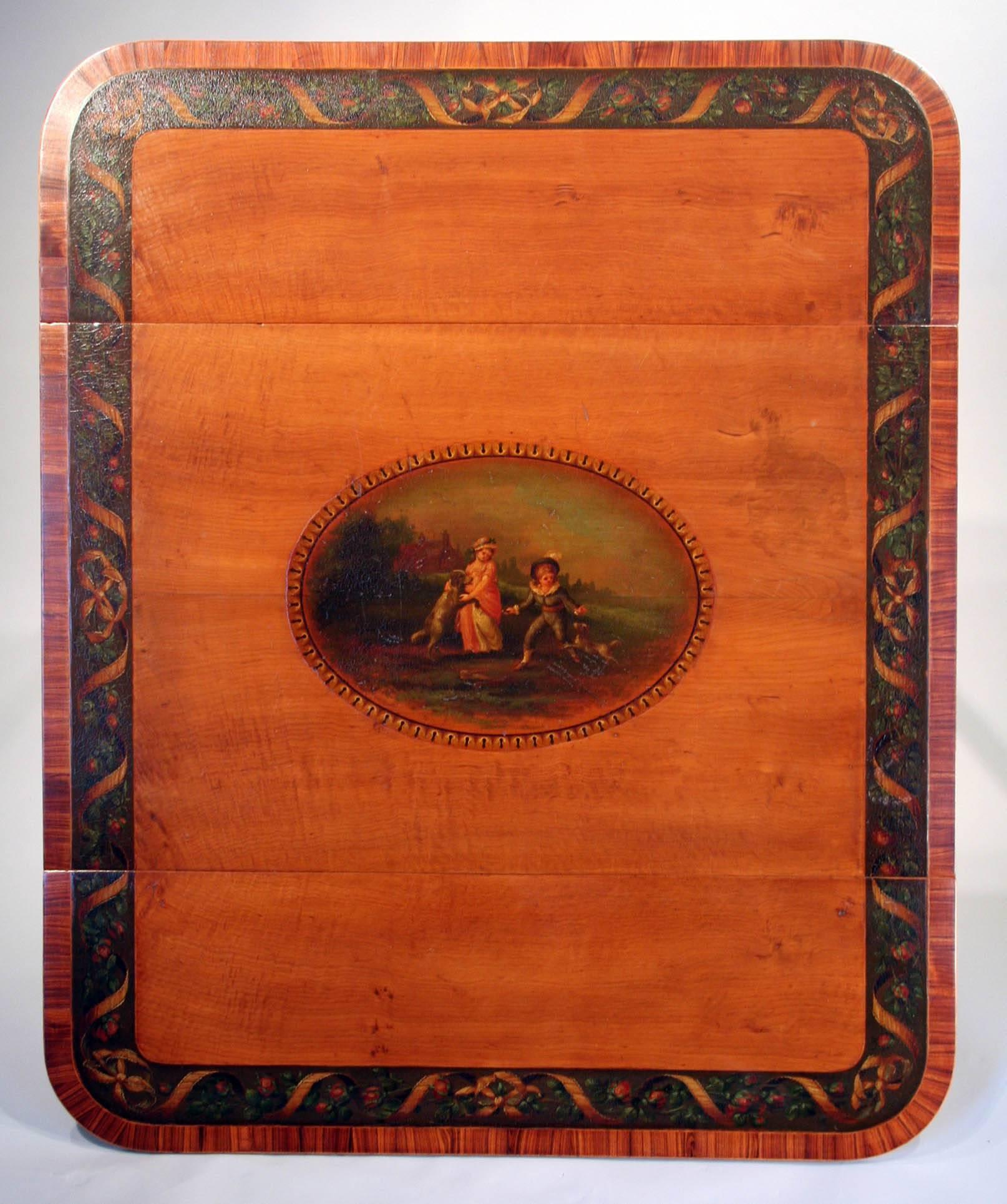 Exceptional George III painted satinwood Pembroke table in the manner of Robert Adam; having rectangular top and two drop leaves with a central painted patterae of children with dogs and a border decorated with ribbon and foliage. Below is a single