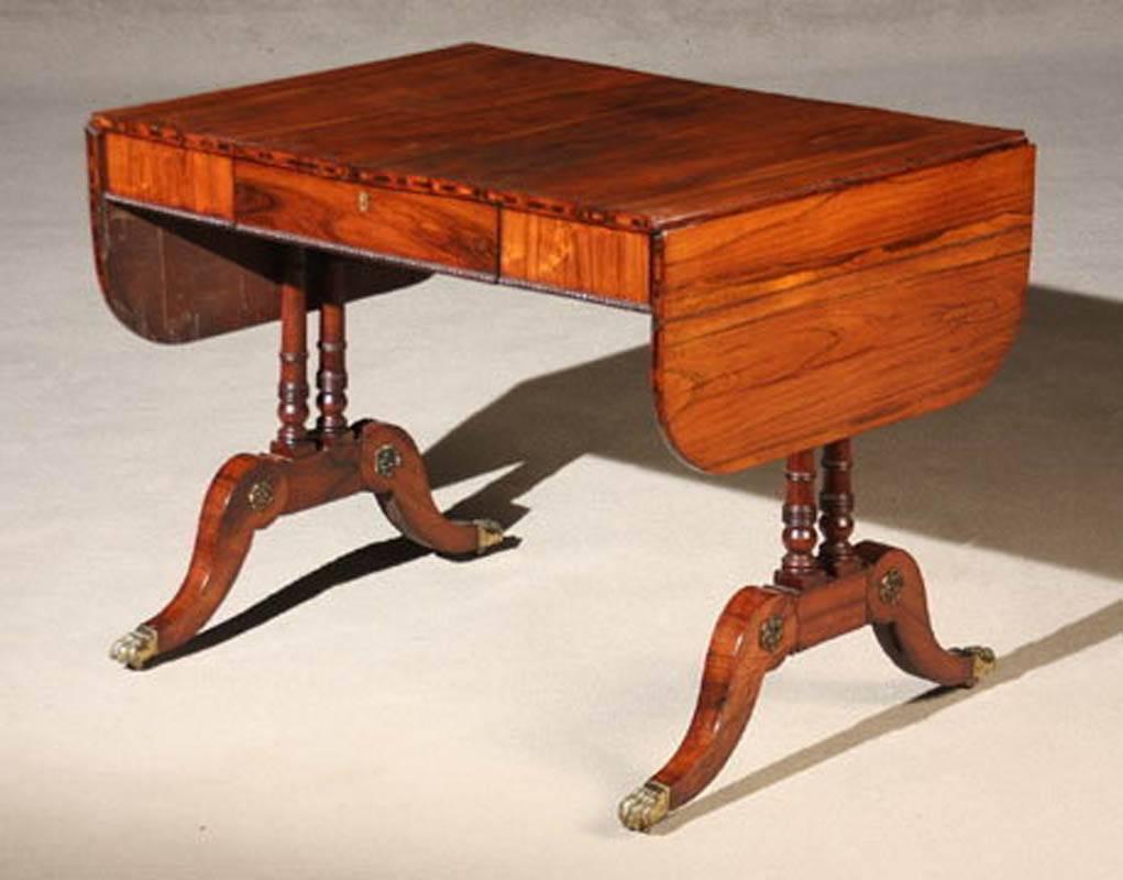 Fine English Regency rosewood sofa table, with “D” form drop leaves. This exceptional example of this form has extraordinary attention to detail. The edge of the top is inlaid with crossbanding the hardly noticed butterflies that support the top