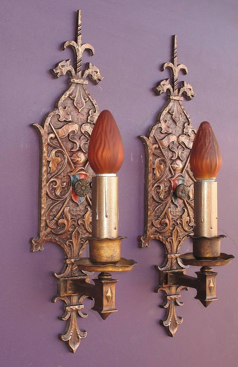 Well designed and sharply cast solid bronze Spanish Revival style sconces with single bulbs. Large in both style and size at 18 3/4 inches high. Original finish and patina has been gently cleaned and lightly waxed.
Dragons, knight in armor, shield,