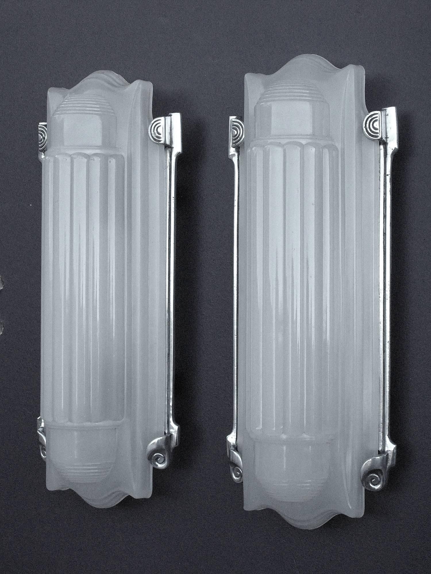Total 3 available, 1 & 1/2 pair.  Single price 1/2 of pair.
What a great pair of vintage 1920s-1930s Art Deco wall fixtures. Minimal yet refined, elegant, and very serious. Mini skyscrapers for your wall. The opaque glass shades nest quietly into