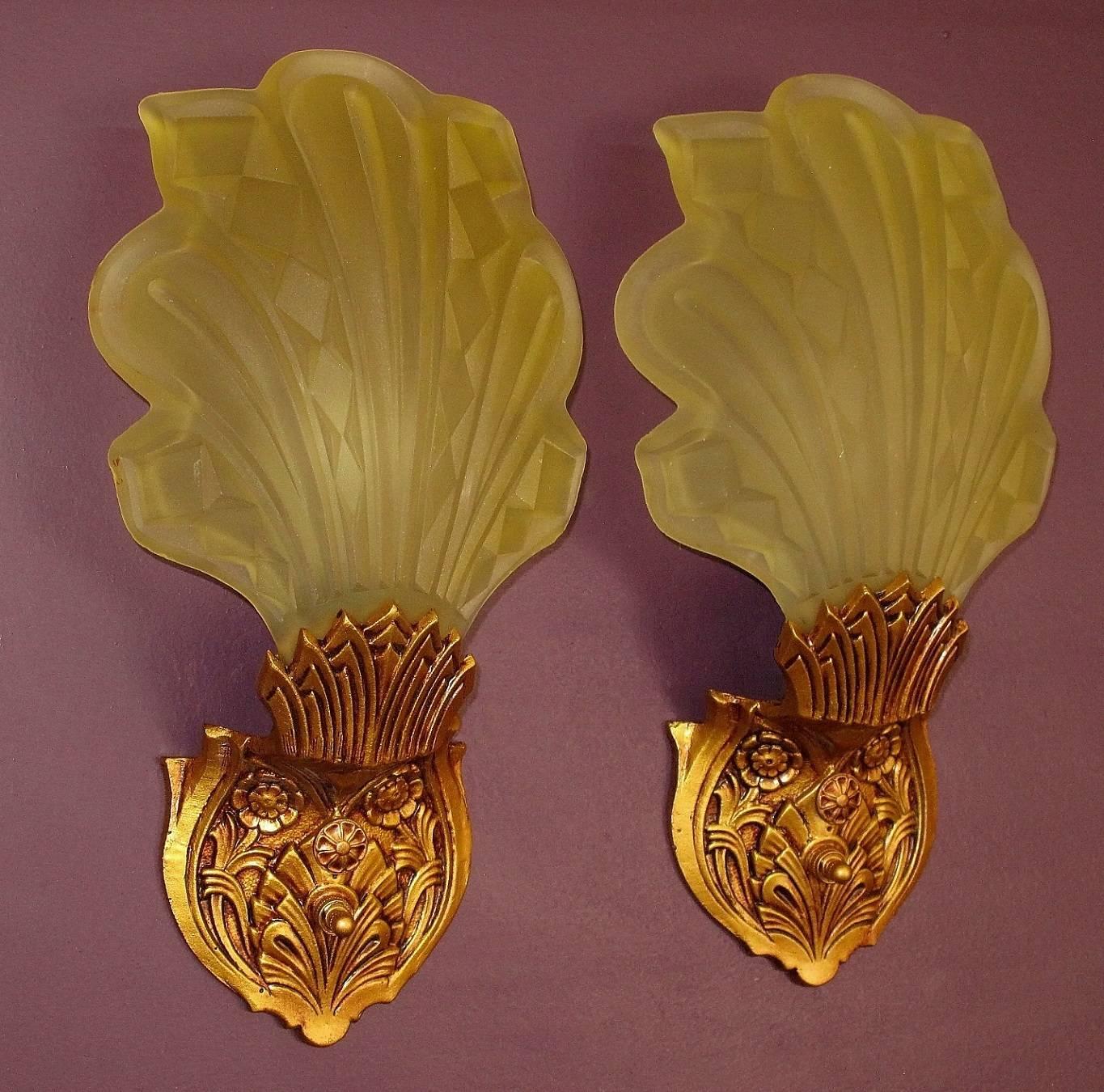 Rather rare and interesting pair of Art Deco era slip shade wall sconces. The designers here were able to capture the feeling of leaves blowing in the wind with the swept back and flowing nature of the shades which seem to grow out of the shade