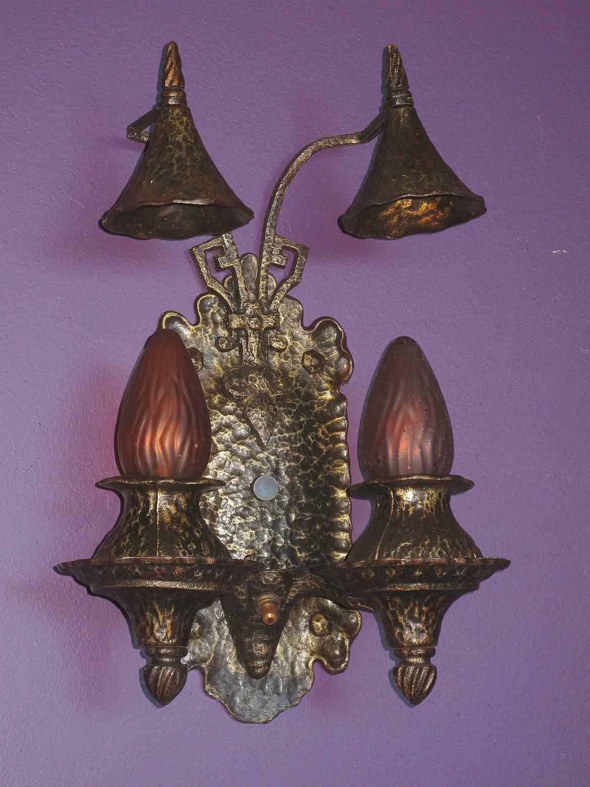 Wonderfully preserved 1920s cast iron wall sconces in a style which would look terrific in any of the Revival styles popular in the 20s including Tudor revival, Spanish Revival, Gothic revival and the Craftsman style. Original finish and patina has