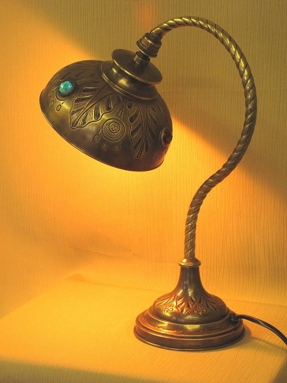 We sourced this little jewel of a Jeweled Table Lamp in Germany. We executed design in the Art Nouveau style. Brass construction. Glass jewels original to the lamp. Rewired for US electricity. 
 Height: 13 1/2 inches with the 
 Width: 6 inches
