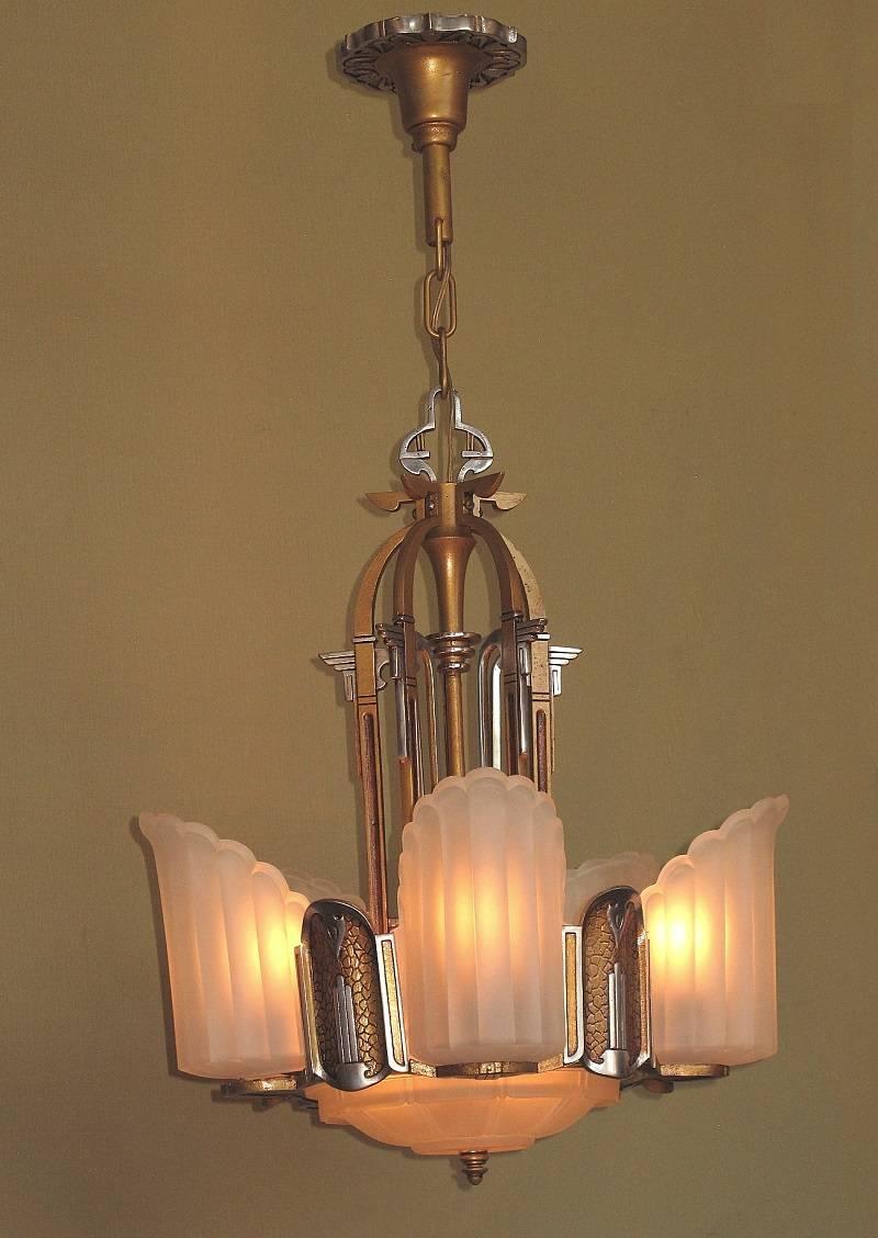A great mix of Art Deco along with the current fads of the day Egyptian Revival and tortoise shell, restored, late 1920s slip shade chandelier. Fixture faithfully restored to it's original colors of sunset golden and polished aluminum. The six clear