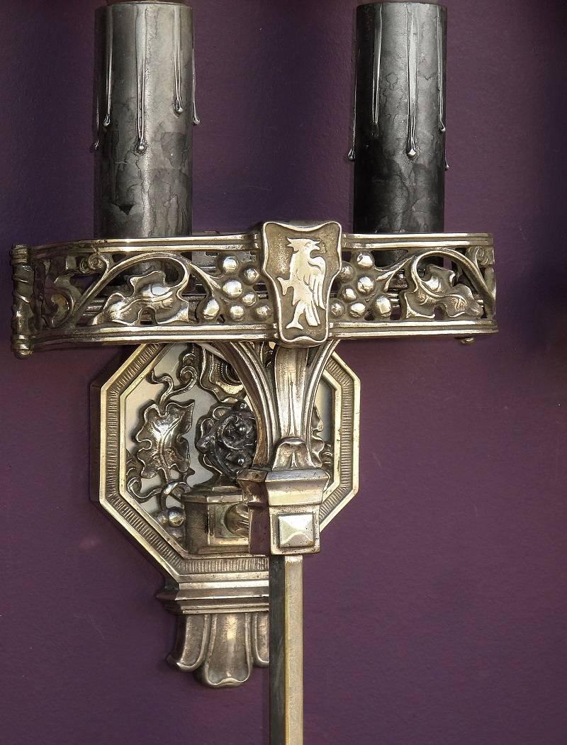 Very well made two candle bulb sconces with original finish of silver or nickel plate over solid cast brass fixtures. The finish has that desirable patina that only comes with years of service. Design and style points to a European influence. Front