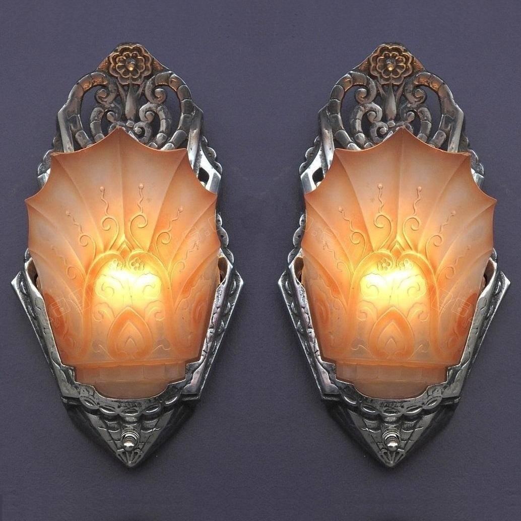 Priced per pair.
 An exuberant display of the creative genius found during the Art Deco period. Both these vintage sconce backs and especially the slip shades are embellished with stylized organic flora symbolizing the optimism of rebirth following