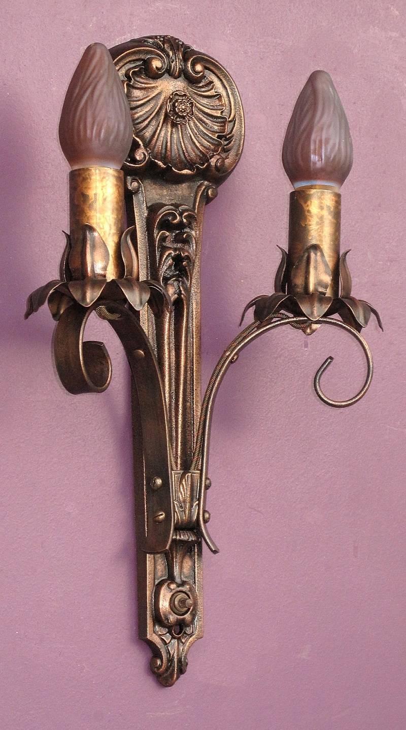 Wonderful vintage two-arm wall sconces with four available, priced each. Classic in design and style with a wonderful shell rosette at top giving them a slight nautical feel. All of these antique sconces are signed 