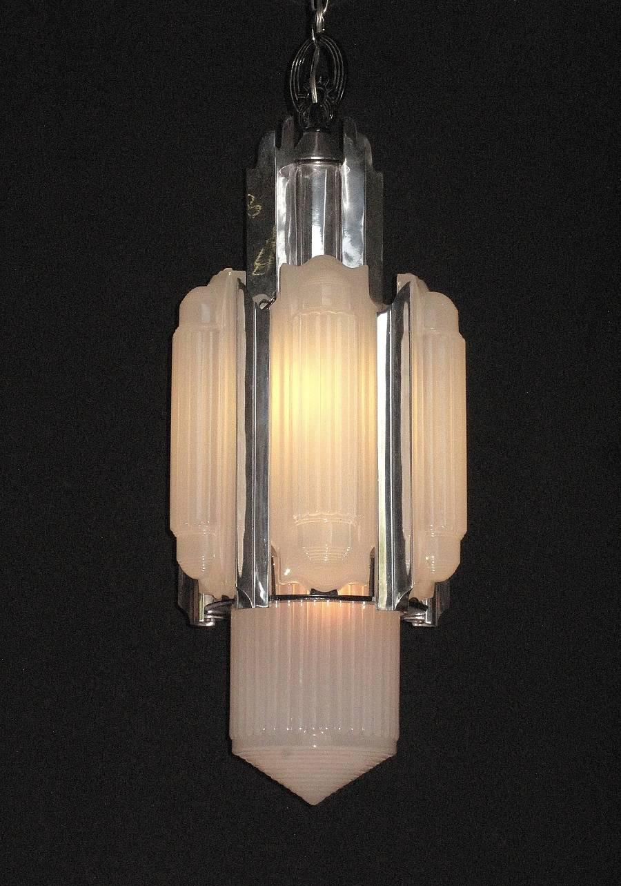 This magnificent Art Deco chandelier is a full four feet in length as shown, with just the body alone 32 inches long. A Great Gatsby fixture to be sure with a leaning towards Mid-Century Modern. This remarkable light fixture is an American original