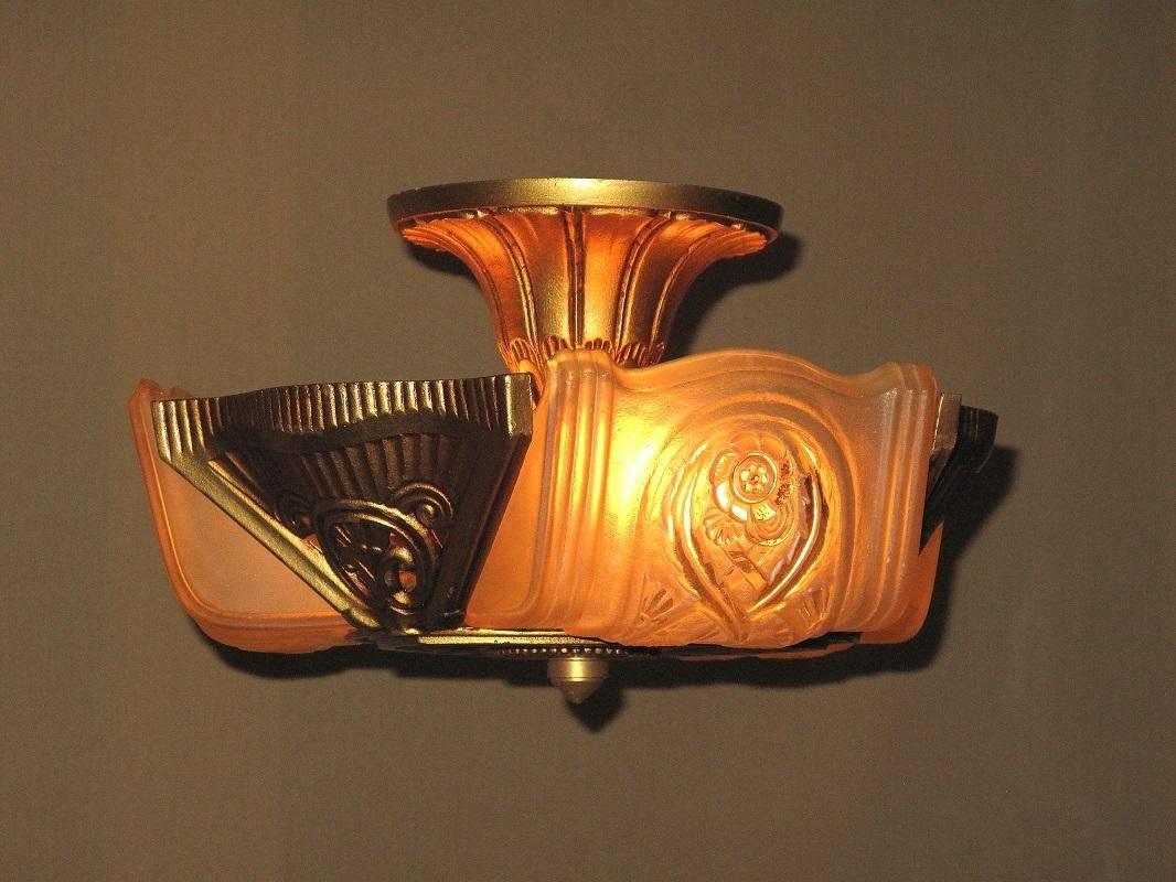 Wonderful Art Deco ceiling fixture where clearance is low but panache is high. Cast Iron construction. Refinished in its original colors of Antique Golden. From Lightolier's After Sunset line. Shades are attributed to Consolidated Glass Co. and are