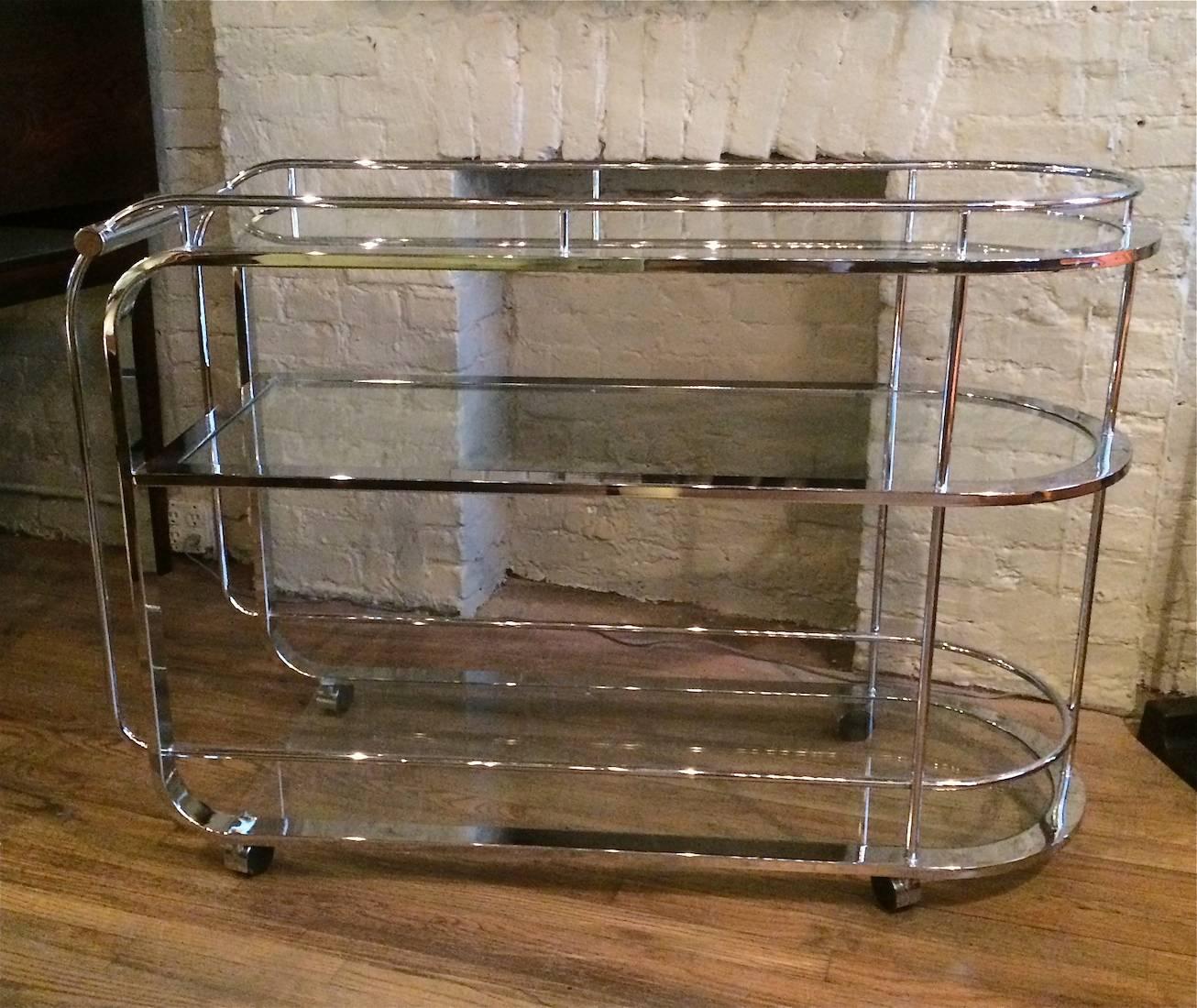 1980s, modern, three-tiered, rolling, bar cart / serving cart with curved tubular chrome frame and glass shelves.