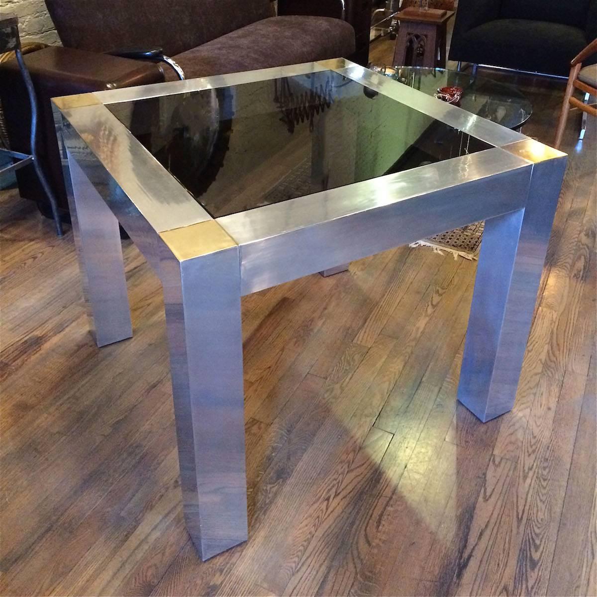 Modern, Parsons style, game or card table with aluminum frame, brass accents and smoke gray glass interior in the manner of Paul Evans.