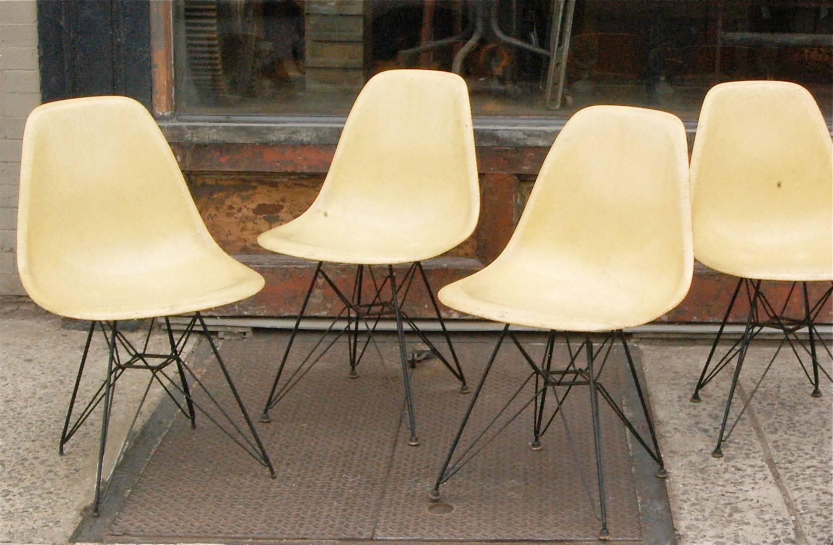Set of four, vintage, yellow, Eames for Herman Miller moulded fiberglass side chairs with Eiffel Tower steel bases.