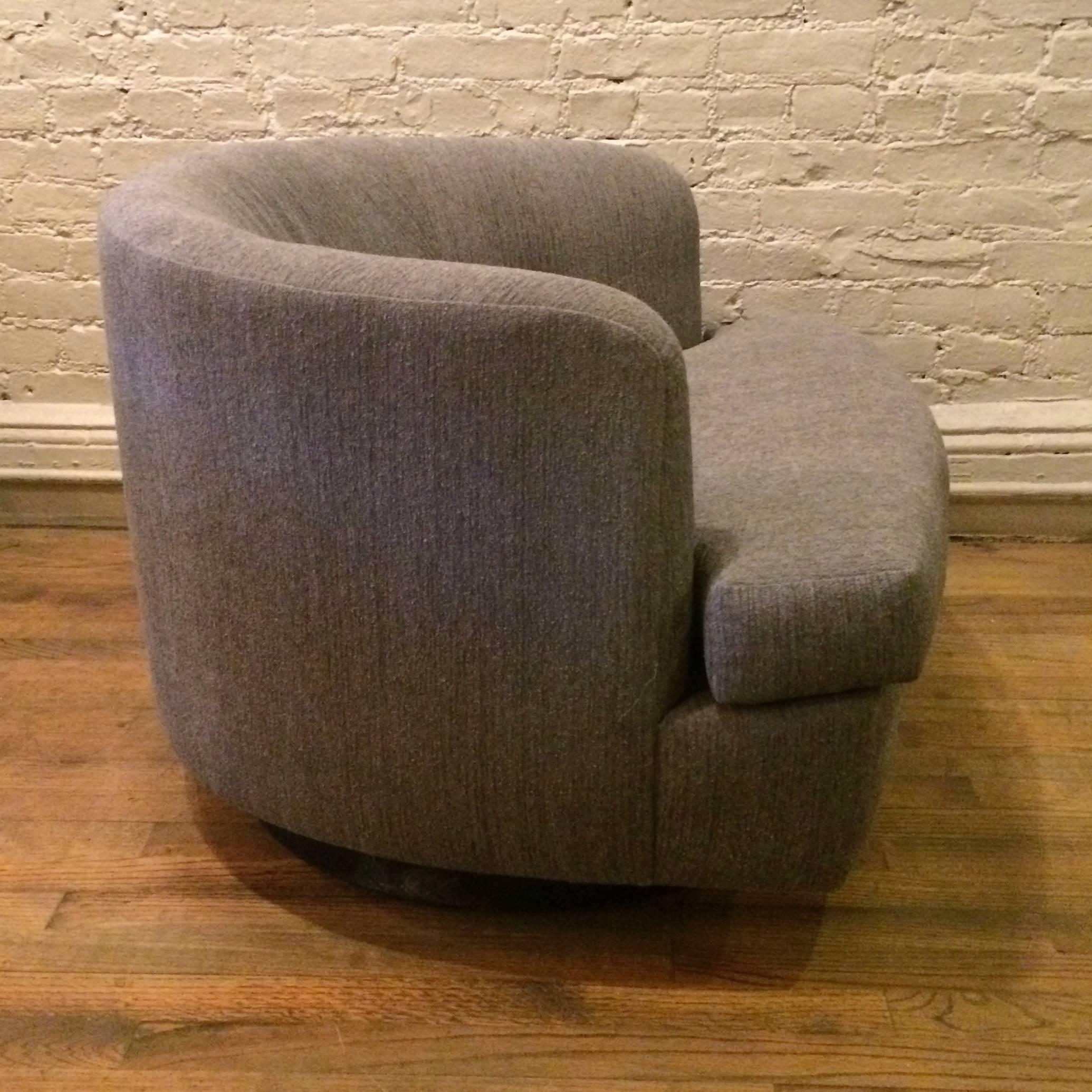 Low profile, plush, barrel shape, club or lounge chair with swivel action is fully upholstered in a soft gray/blue chenille.