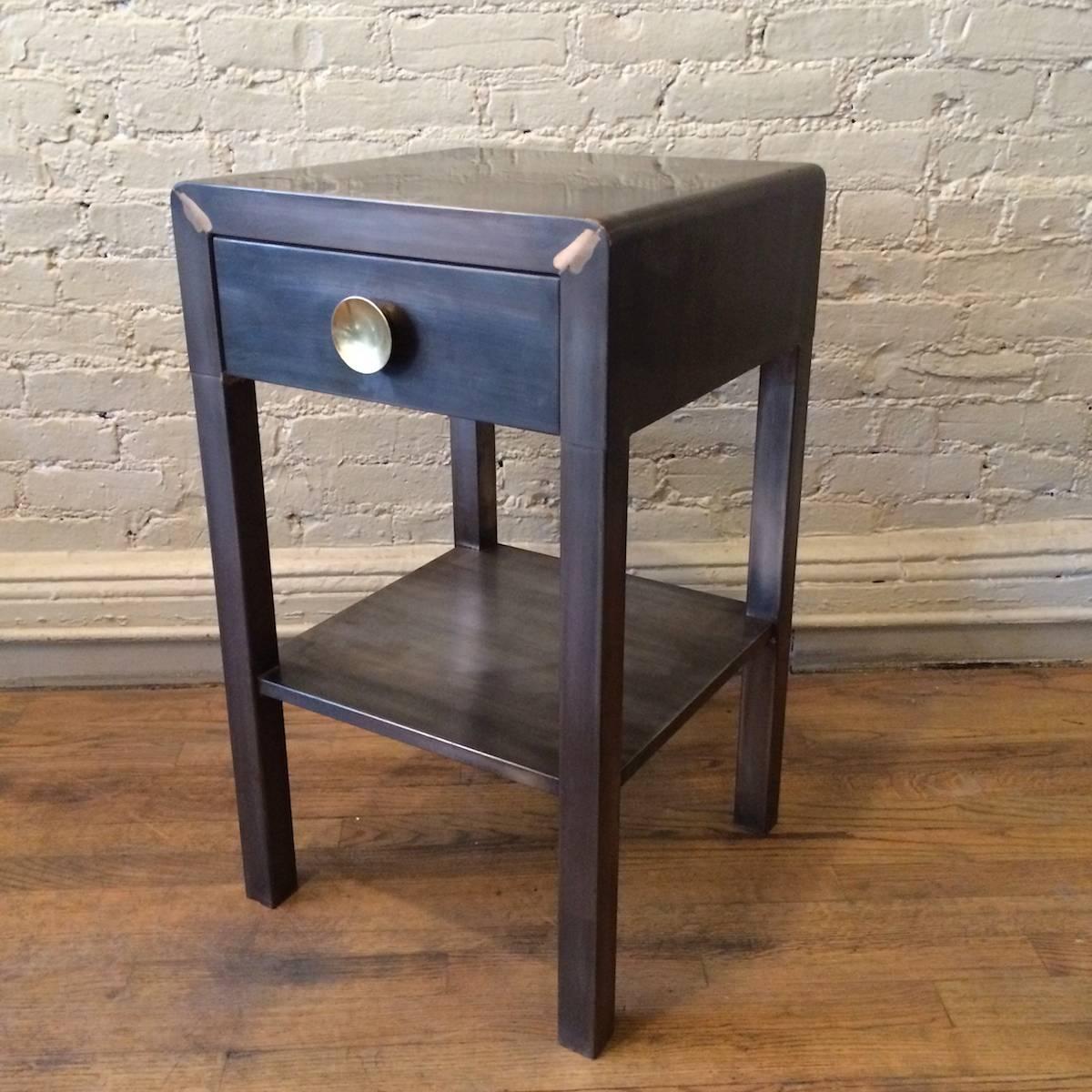Machine Age, brushed steel, side table / nightstand designed by Norman Bel Geddes for Simmons Furniture Company is newly restored in a gunmetal finish with contrasting brass-plated handle.