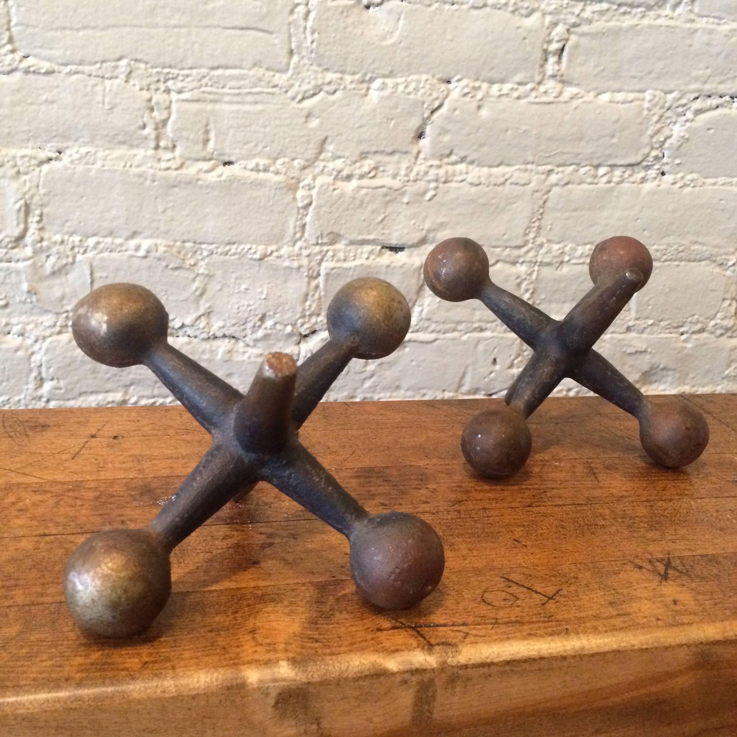 Finely patinated pair of oversized, cast iron jacks work can be used as bookends, doorstops or decorative objects.