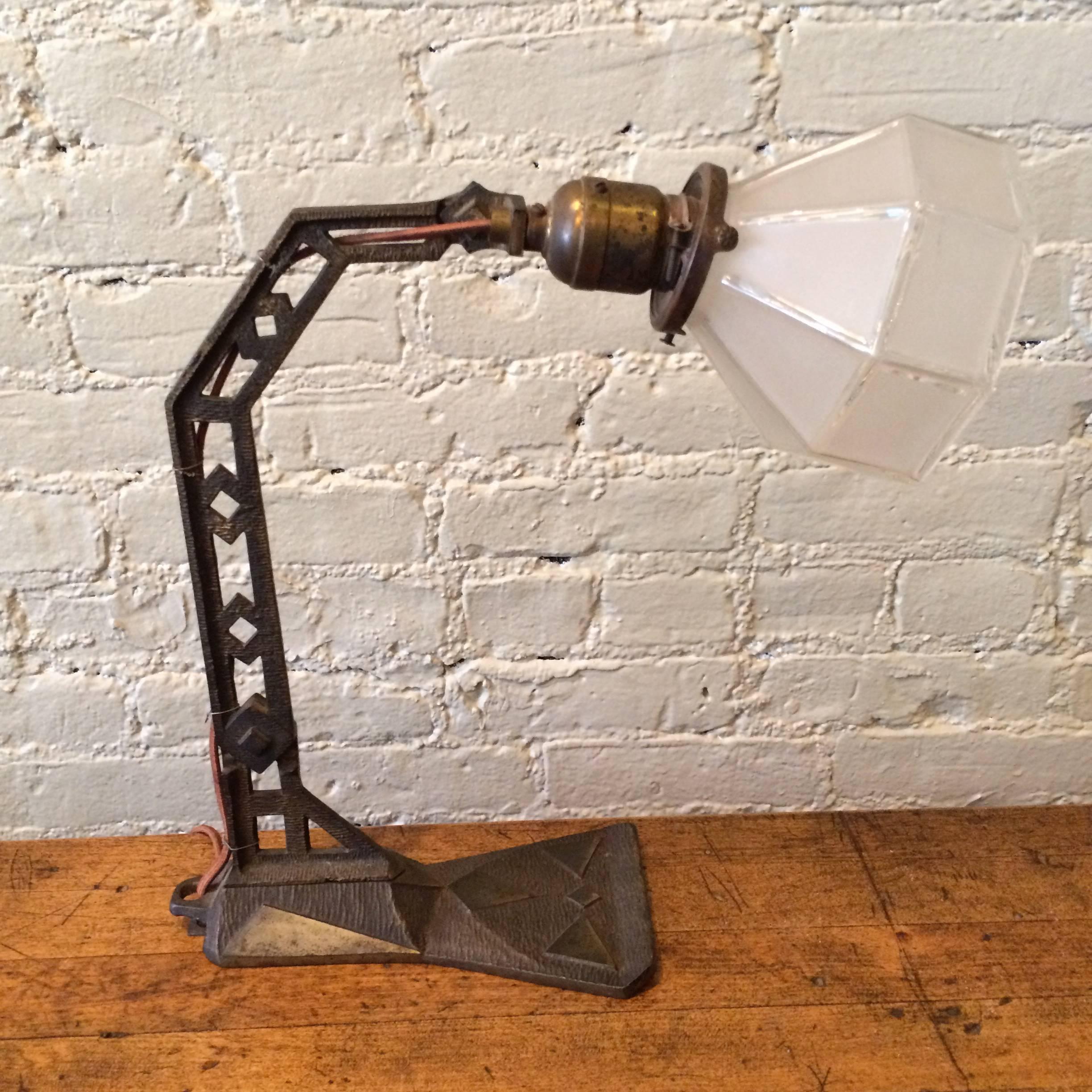 Wonderfully detailed, articulating, Arts & Crafts, cast iron table lamp with frosted glass shade.