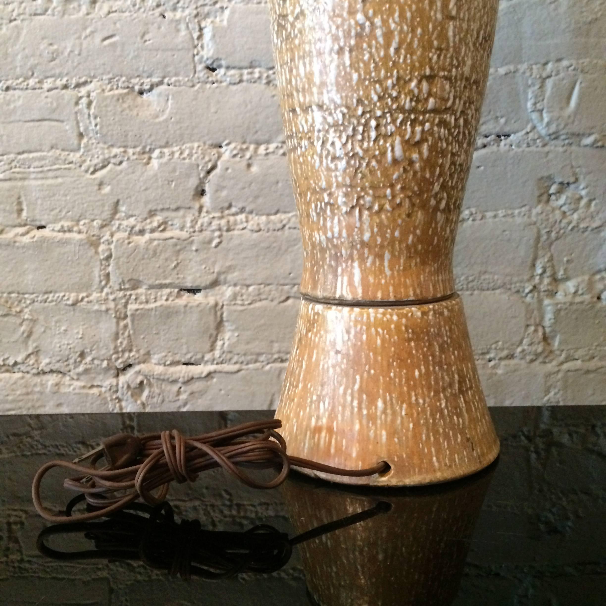 Mid-Century Modern, tall, ceramic, art pottery table lamp with textured, tan and white, elongated, oblong body.