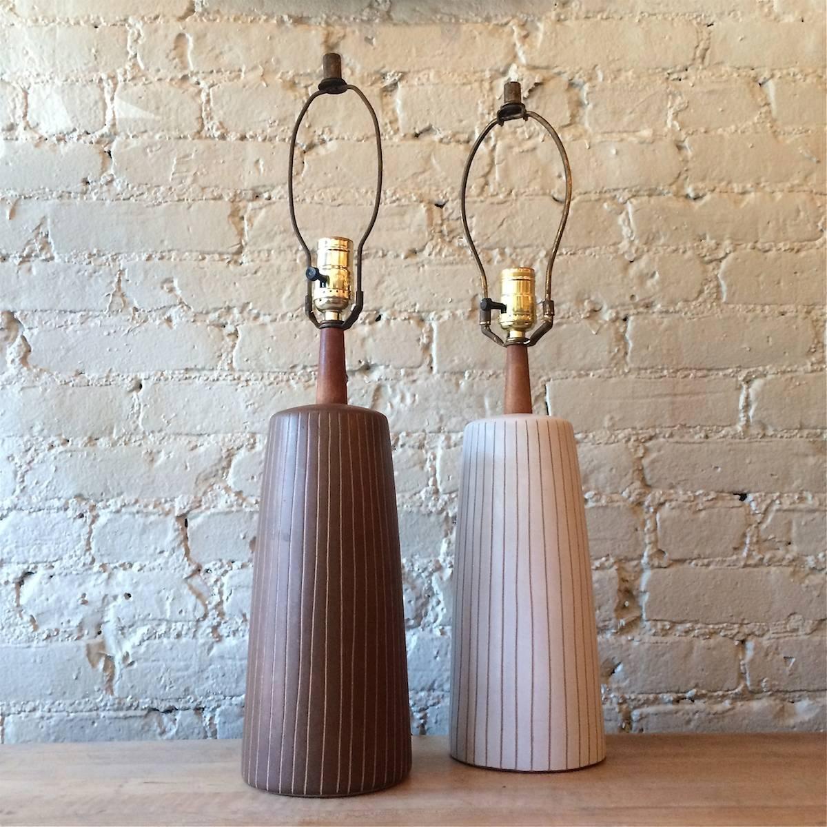 Pair of contrasting, brown and cream, incised ceramic, art pottery, table lamps by Gordon Martz for Marshall Studios with teak accents.