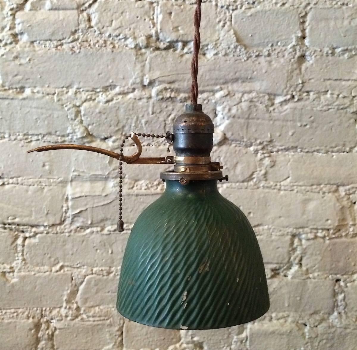 Petite, green, X-ray mercury glass pendant light with patented brass extension arm chain pull fitter is newly wired with braided cord and able to take bulbs up to 200 watts.