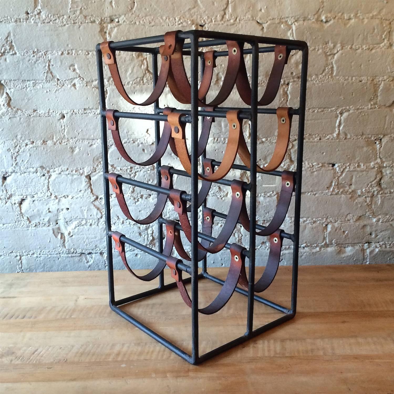 Mid-Century Modern, wrought iron wine rack with leather straps by Arthur Umanoff holds eight bottles.