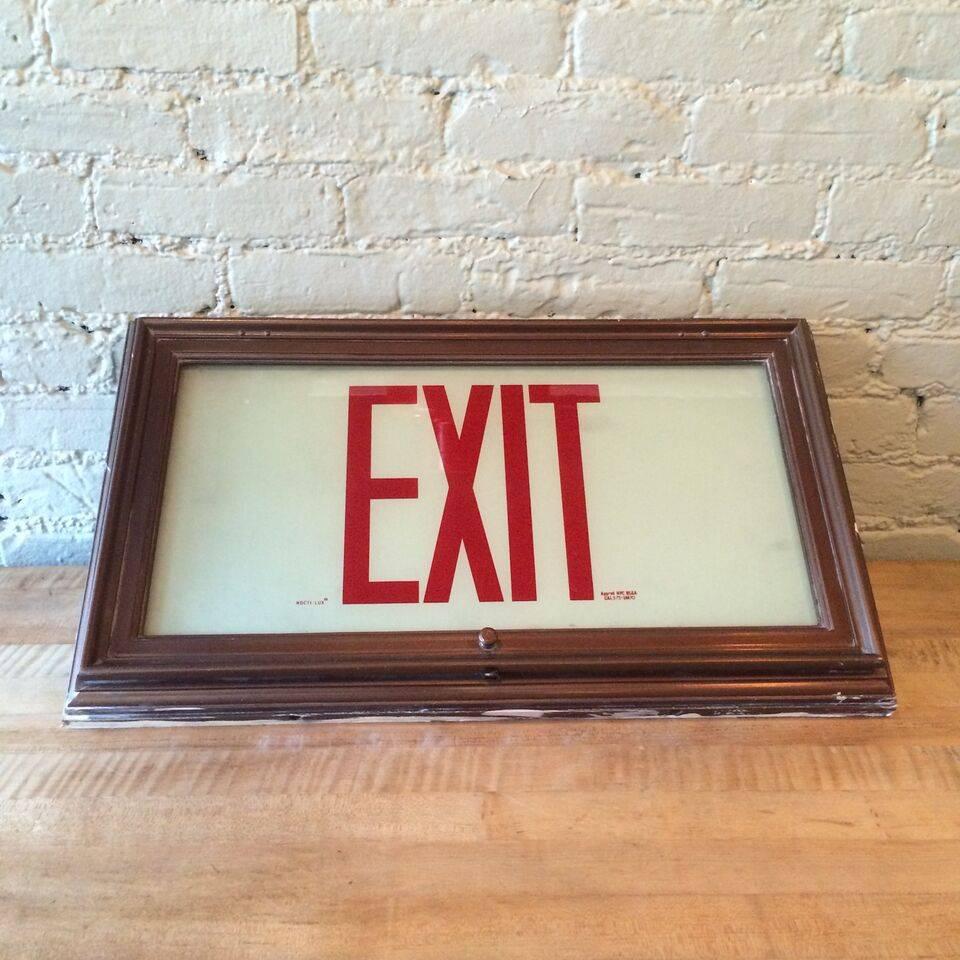 Recessed, flush mount exit sign light, wall sconce with molded metal frame and glow-in-the-dark frosted glass, circa 1930s. Features two medium socket bulbs.