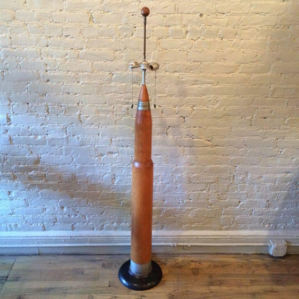 Incredible, handmade, Machine Age, post World War II, trench art, floor lamp made from a maple training missile mounted on a cast iron base with dog-tag chain and shell casing light pulls.