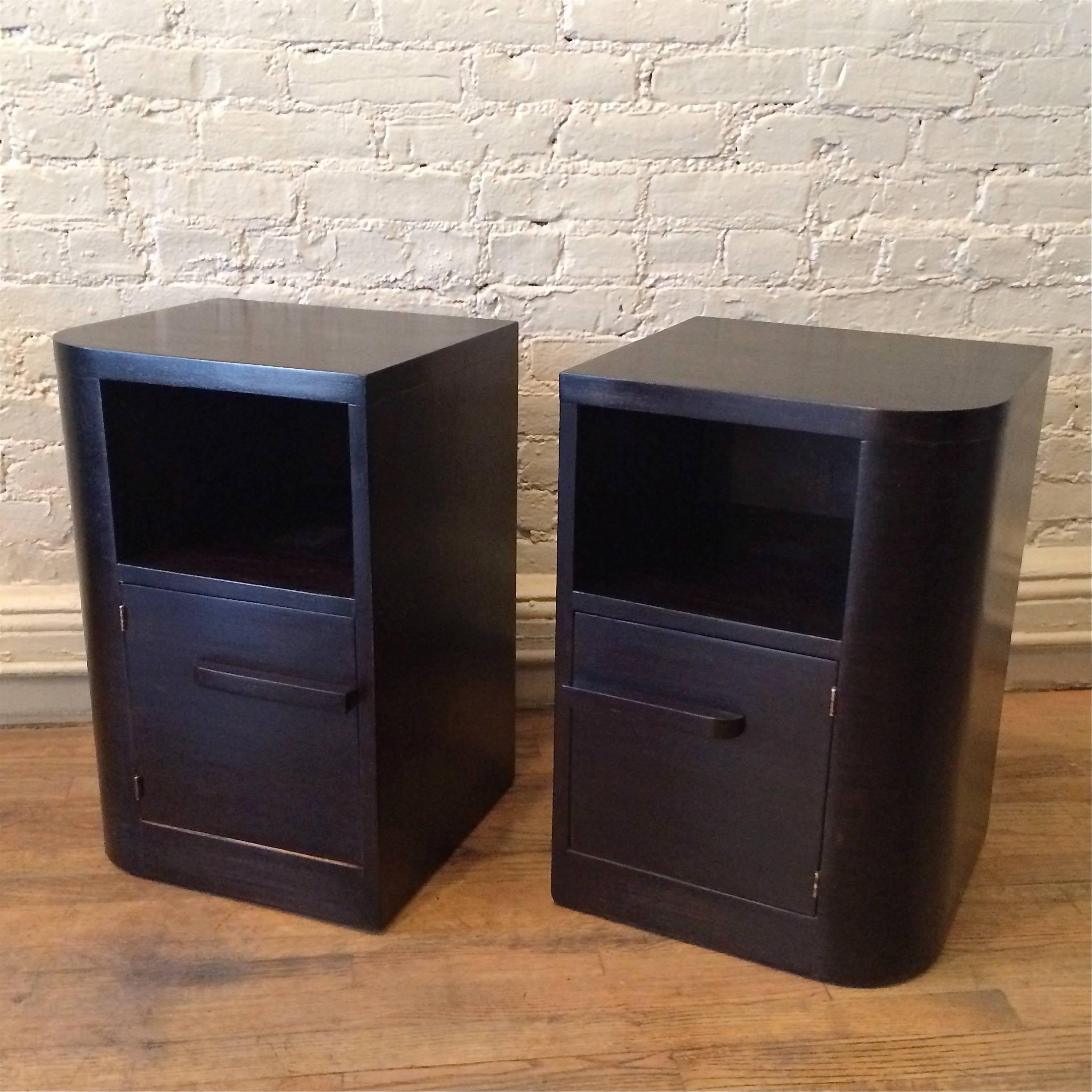 Pair of Art Deco, ebonized maple, nightstands or end tables by Modernage Furniture Company with curved outer edge and open and closed storage.