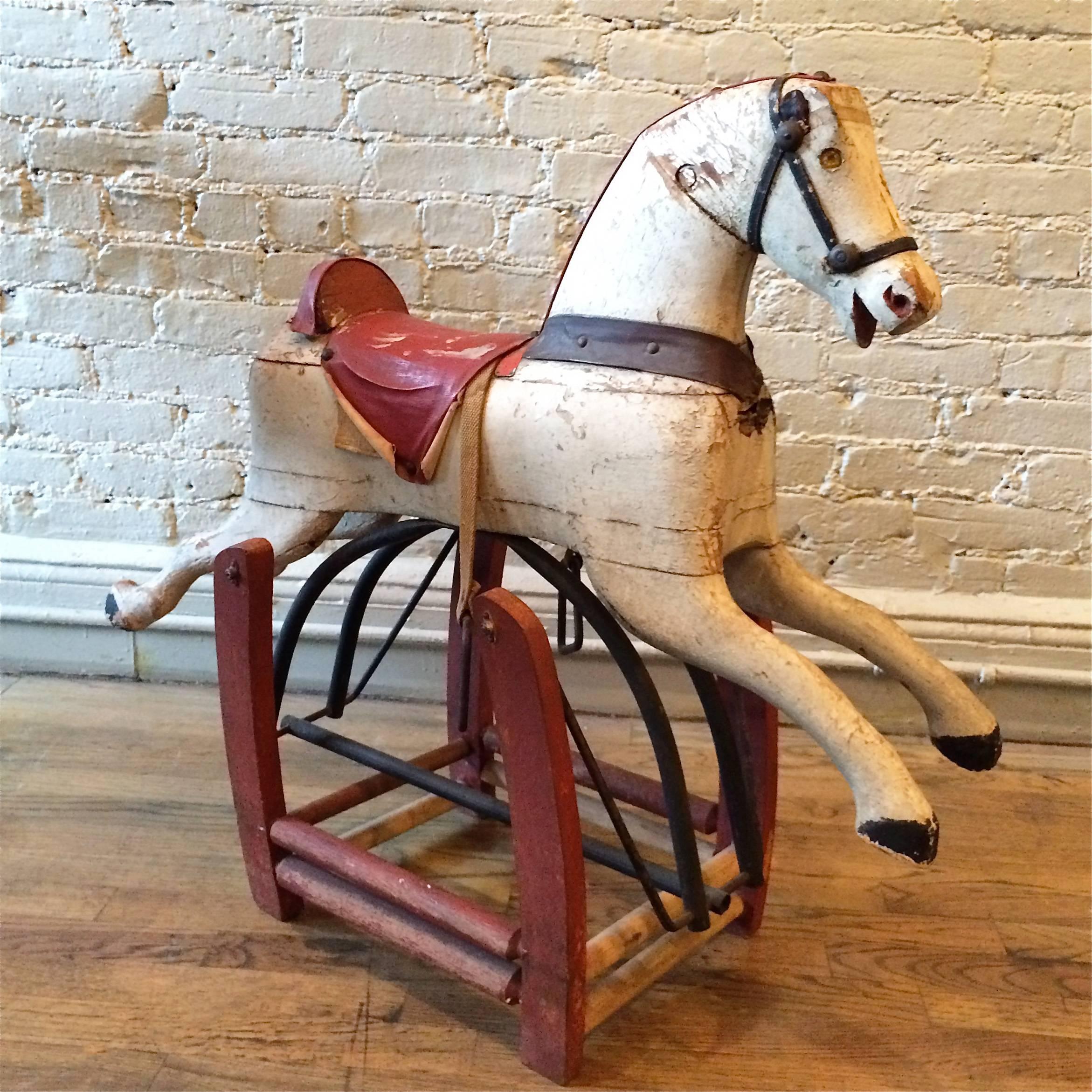 19th century, antique, primitive, folk art, rocking horse is painted wood on an iron glider mechanism. It's wonderful patina is all original.