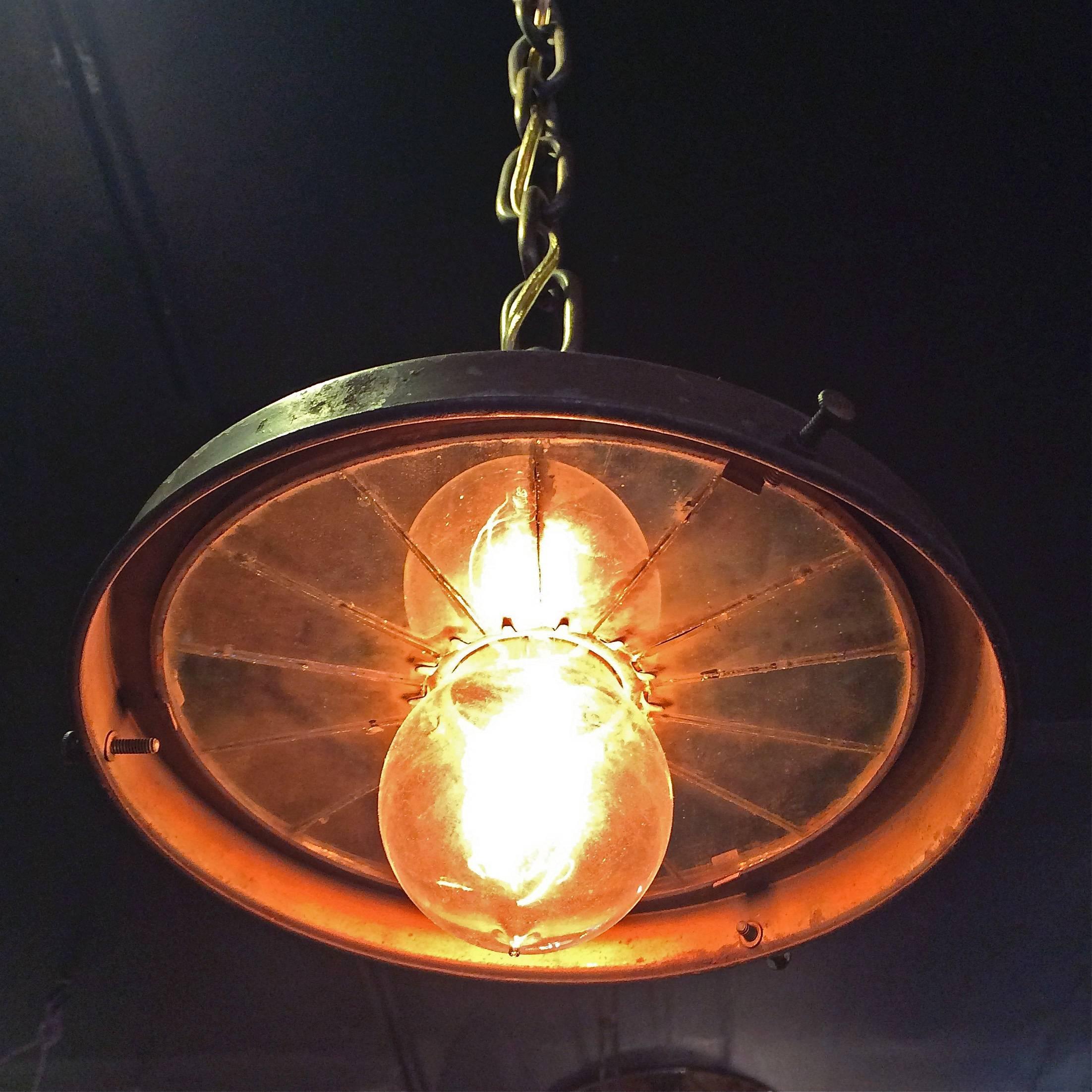 Industrial, factory pendant lights are brass with faceted mirror inserts that hang down 36" on brass chains. Pendants are in original condition.