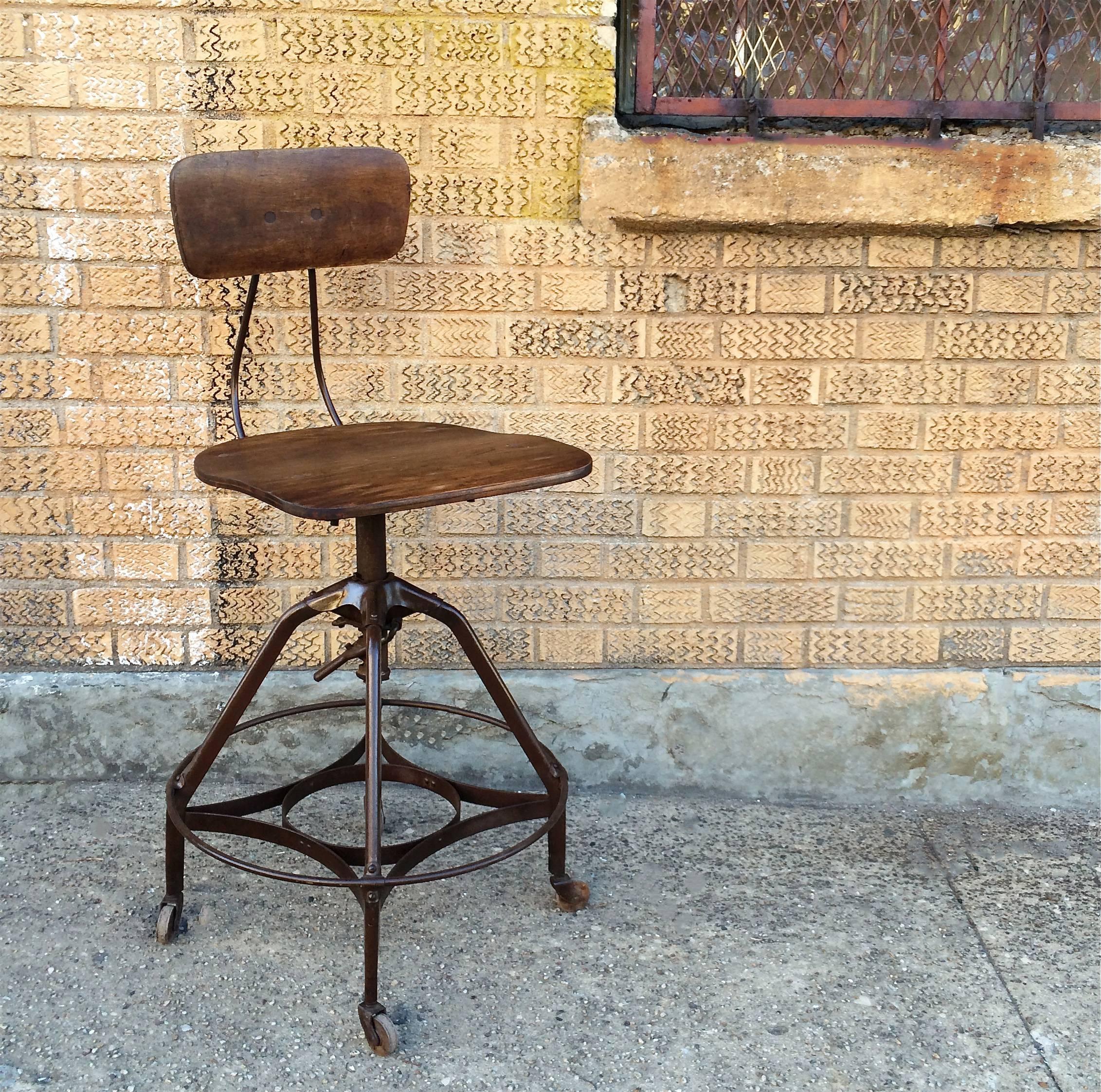 Early, Industrial drafting stool by Toledo Metal Furniture Co. with oak seat and back and painted steel frame. Seat height adjustable from 24