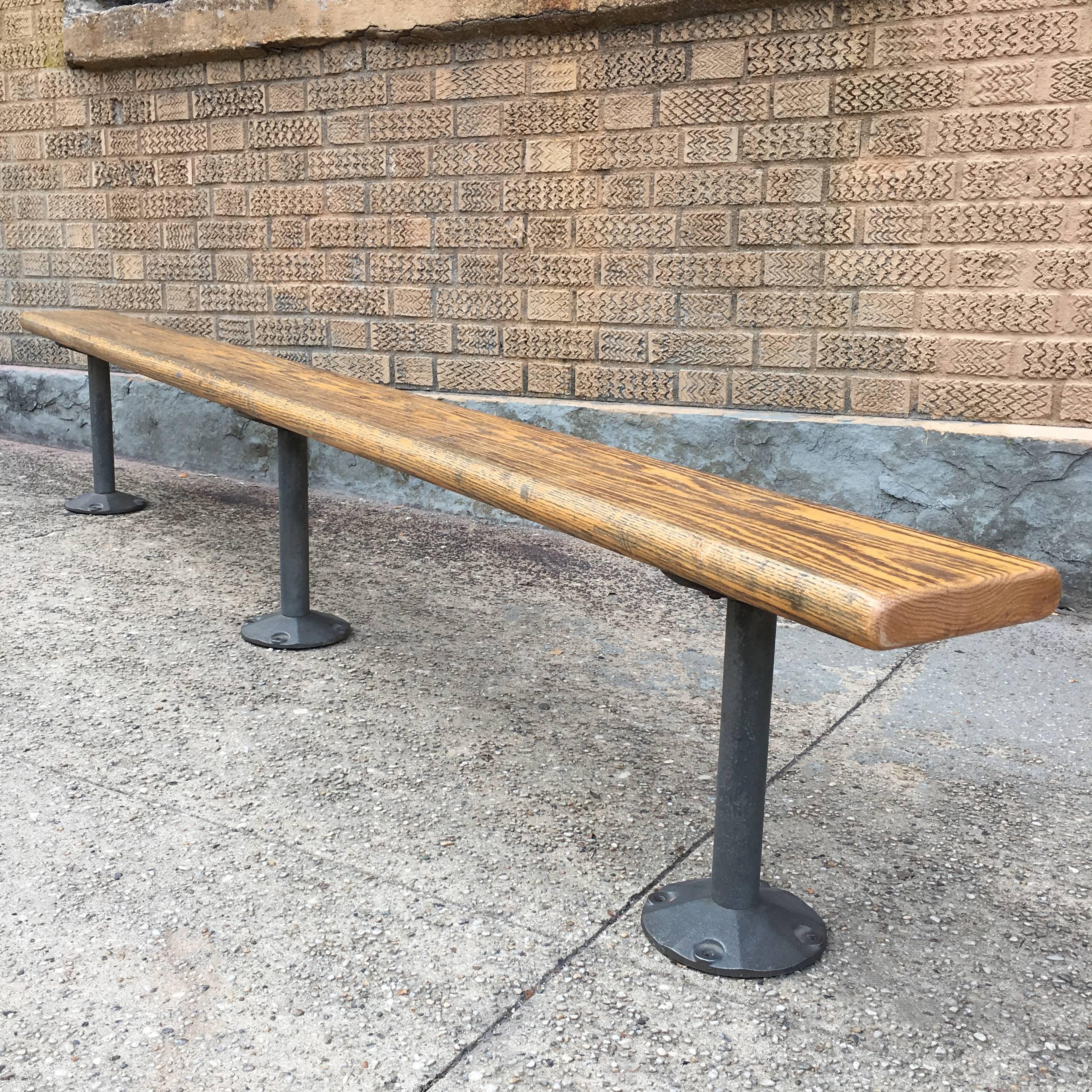 American, gymnasium bench with cast iron legs and oak plank top. It is recommended this bench be secured to the floor for use.