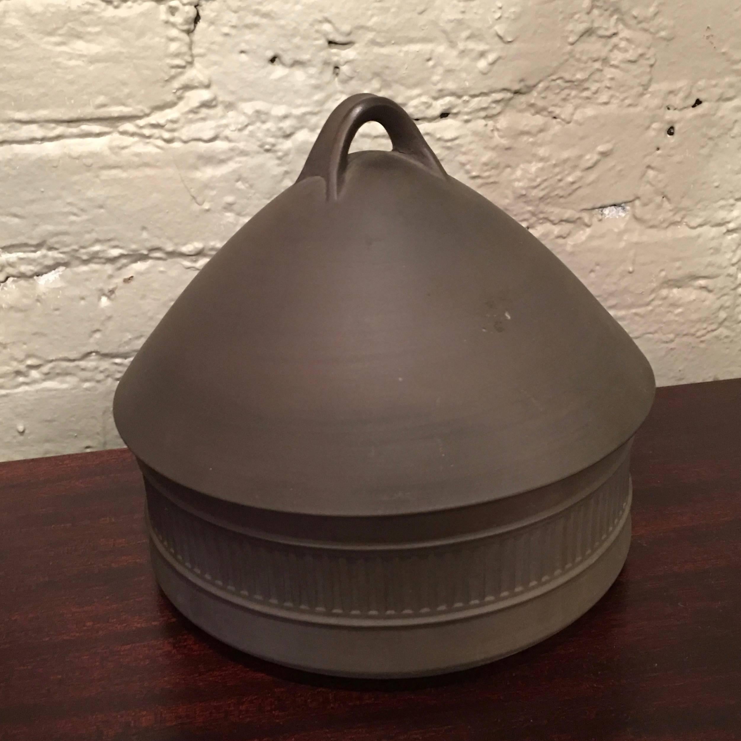 Danish modern, Flamestone cookware, beehive dish with cover by Jens Quistgaard for Dansk featuring a dark matte grey exterior with white glazed interior.

 