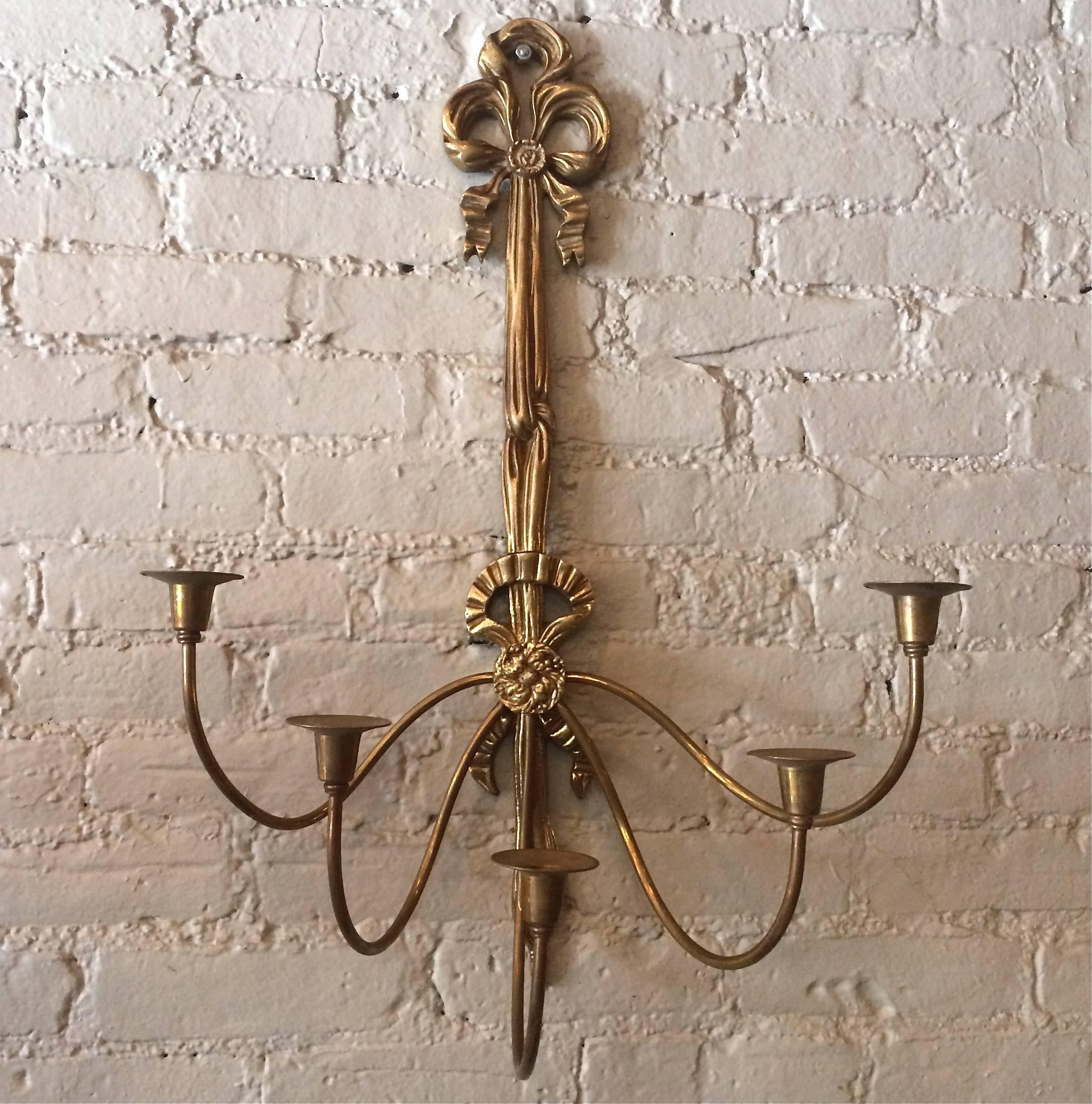 1960s, Hollywood Regency, solid brass, wall candelabra and candle sconce is decorated in a ribbon motif.