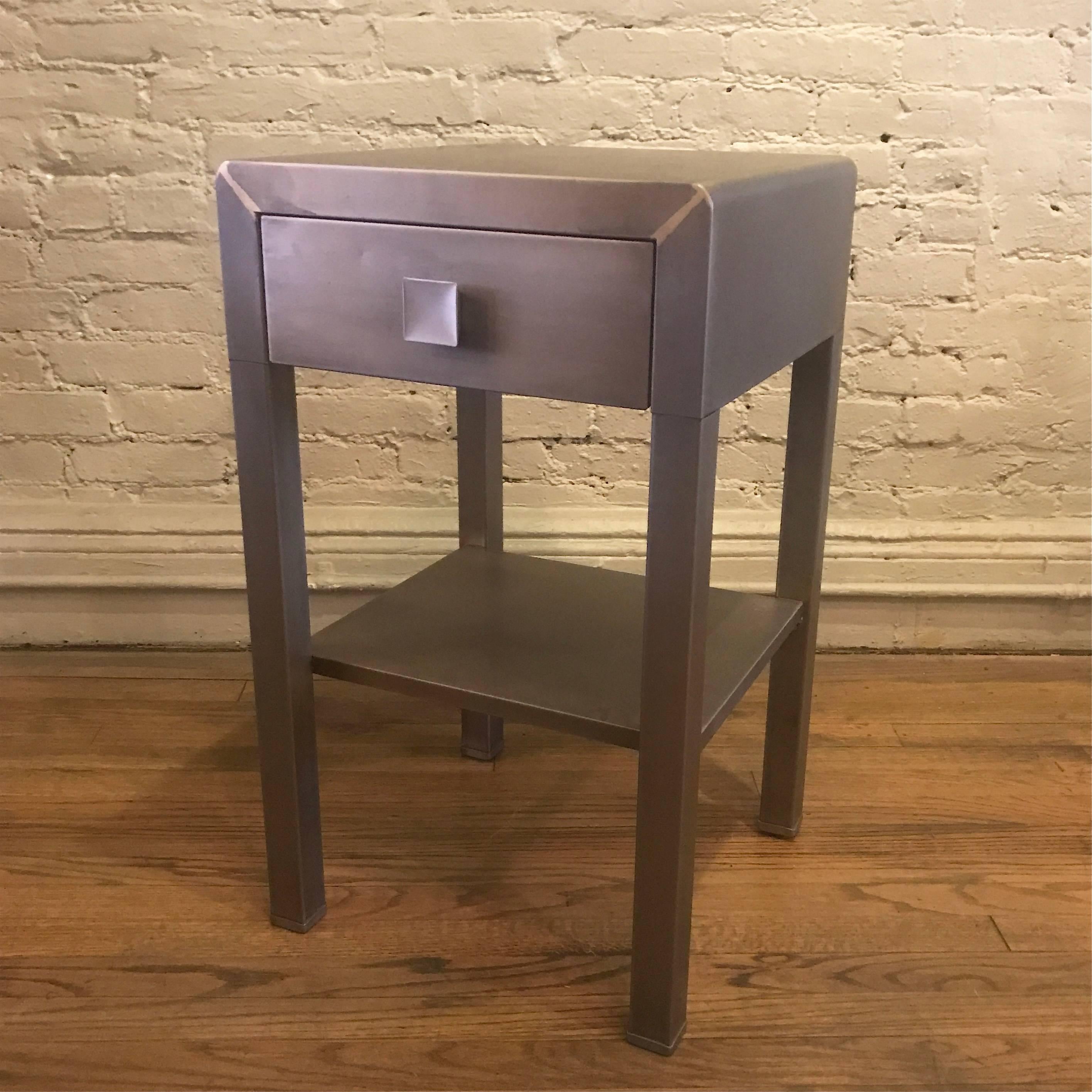 Art Deco, machine age, Industrial side table or nightstand designed by Norman Bel Geddes for Simmons Furniture Company is newly restored in a brushed steel finish.