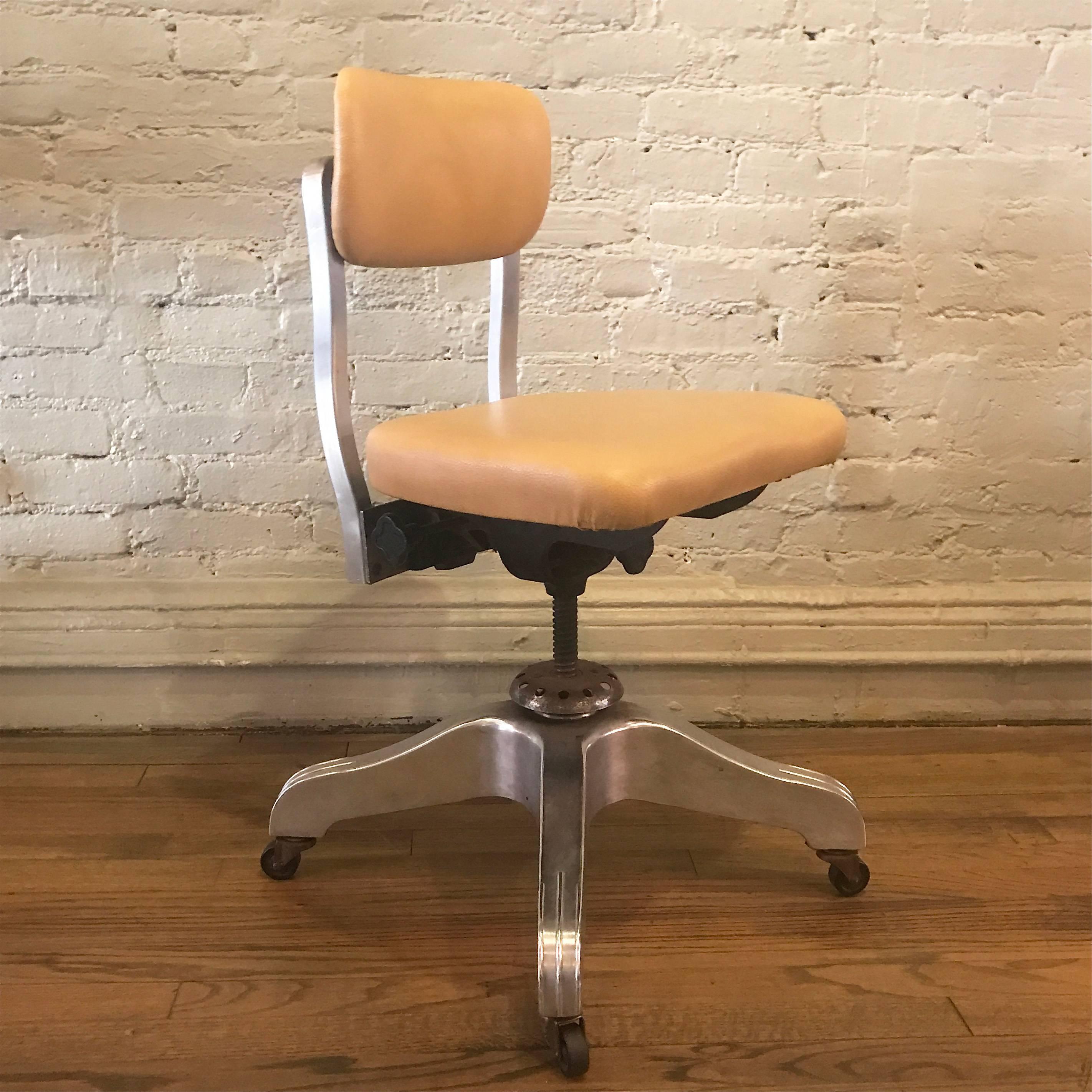 Industrial, atomic-age, aluminum, rolling, goodform, office, desk chair by the general fireproofing company is height adjustable and features newly upholstered seat and back in textured, buttery tan leather.