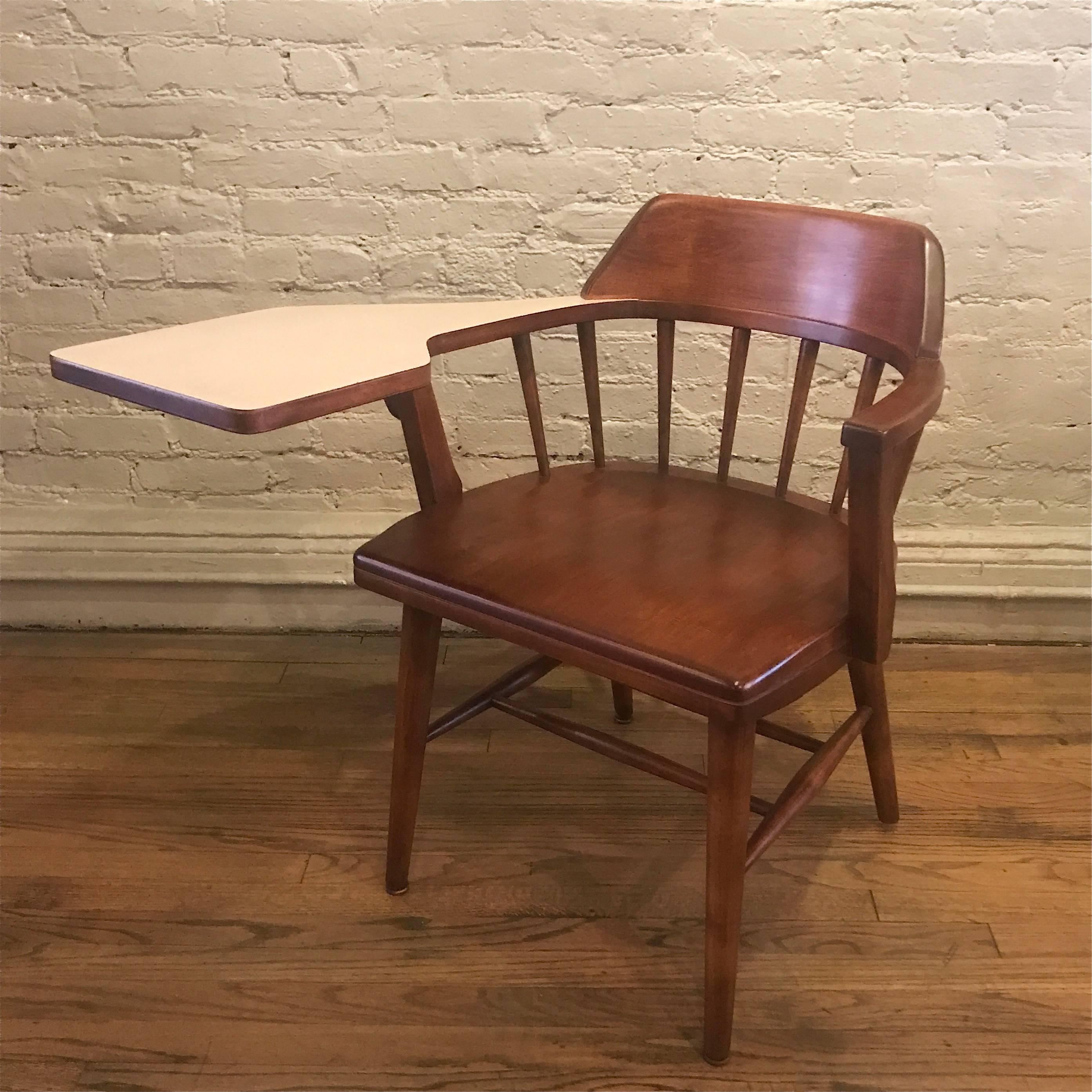 Full size, maple, student's chair features an attached arm desk with laminate top and spindle back by Gunlocke.